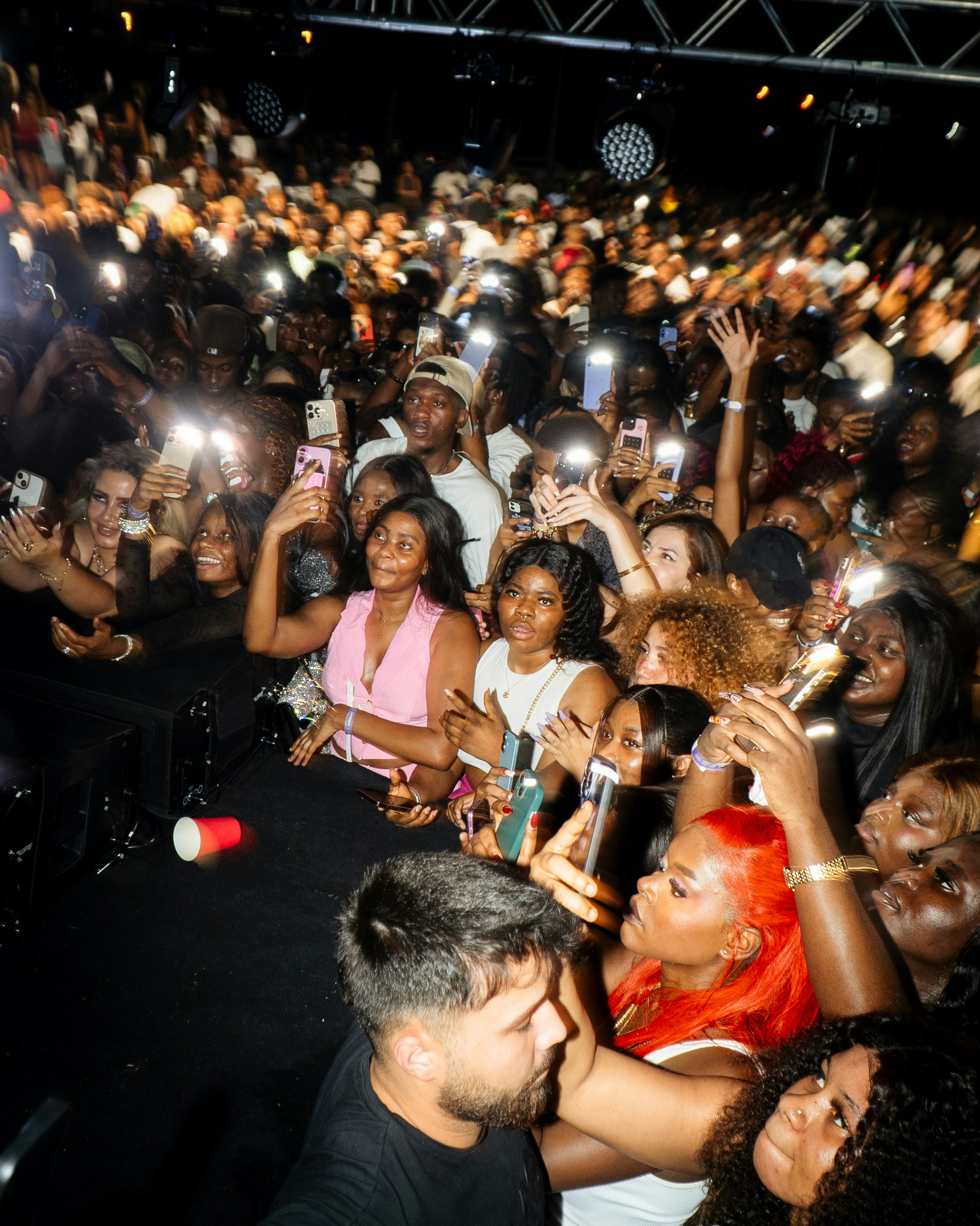 Crowd cheering with cell phones at a concert
