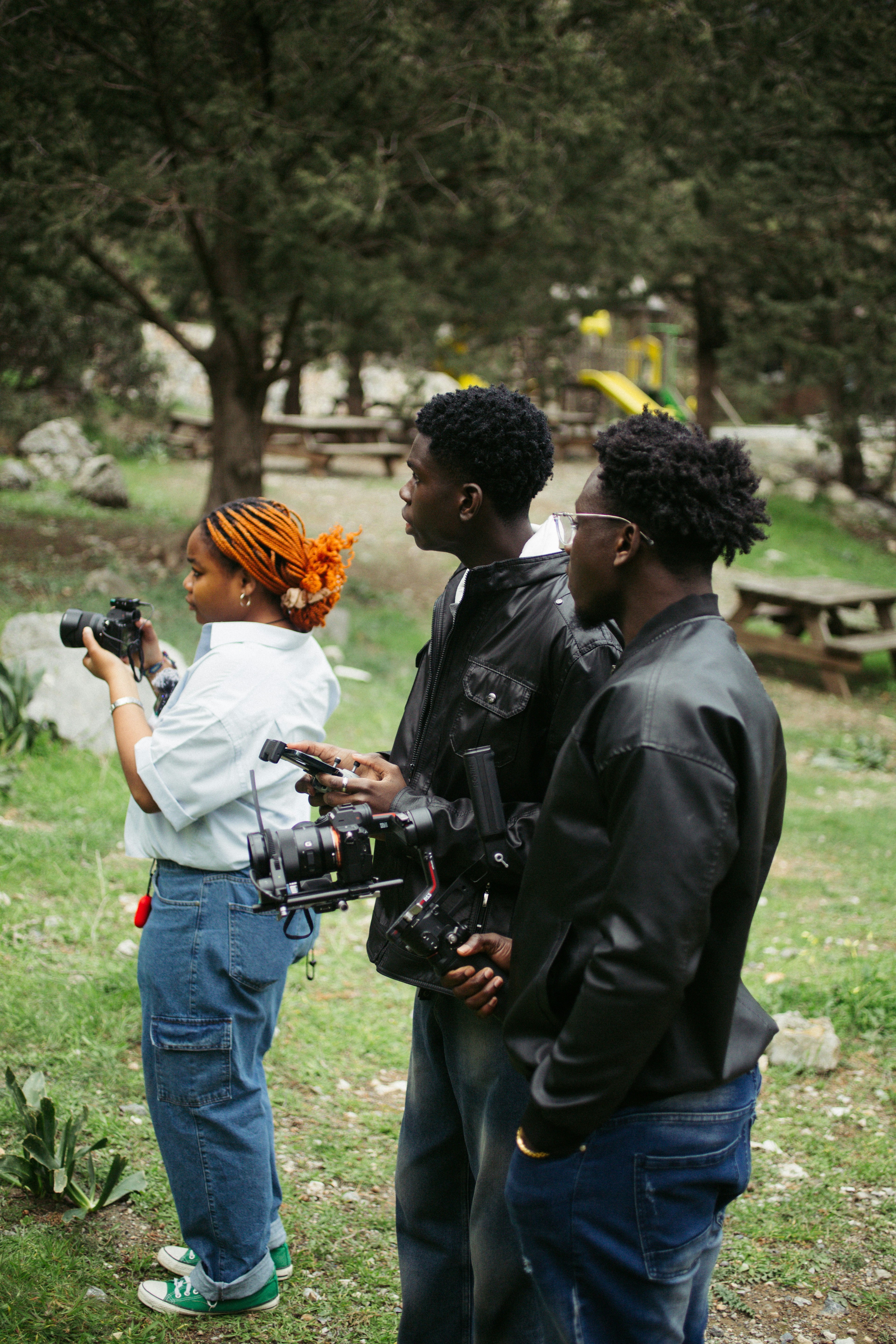 Three people filming outdoors with cameras and equipment. photo – Free ...