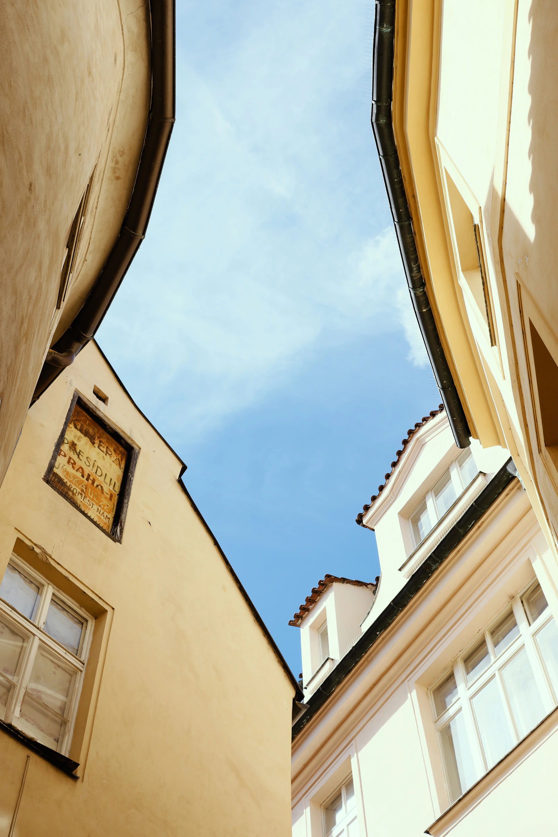 Buildings framing a bright blue sky with clouds
