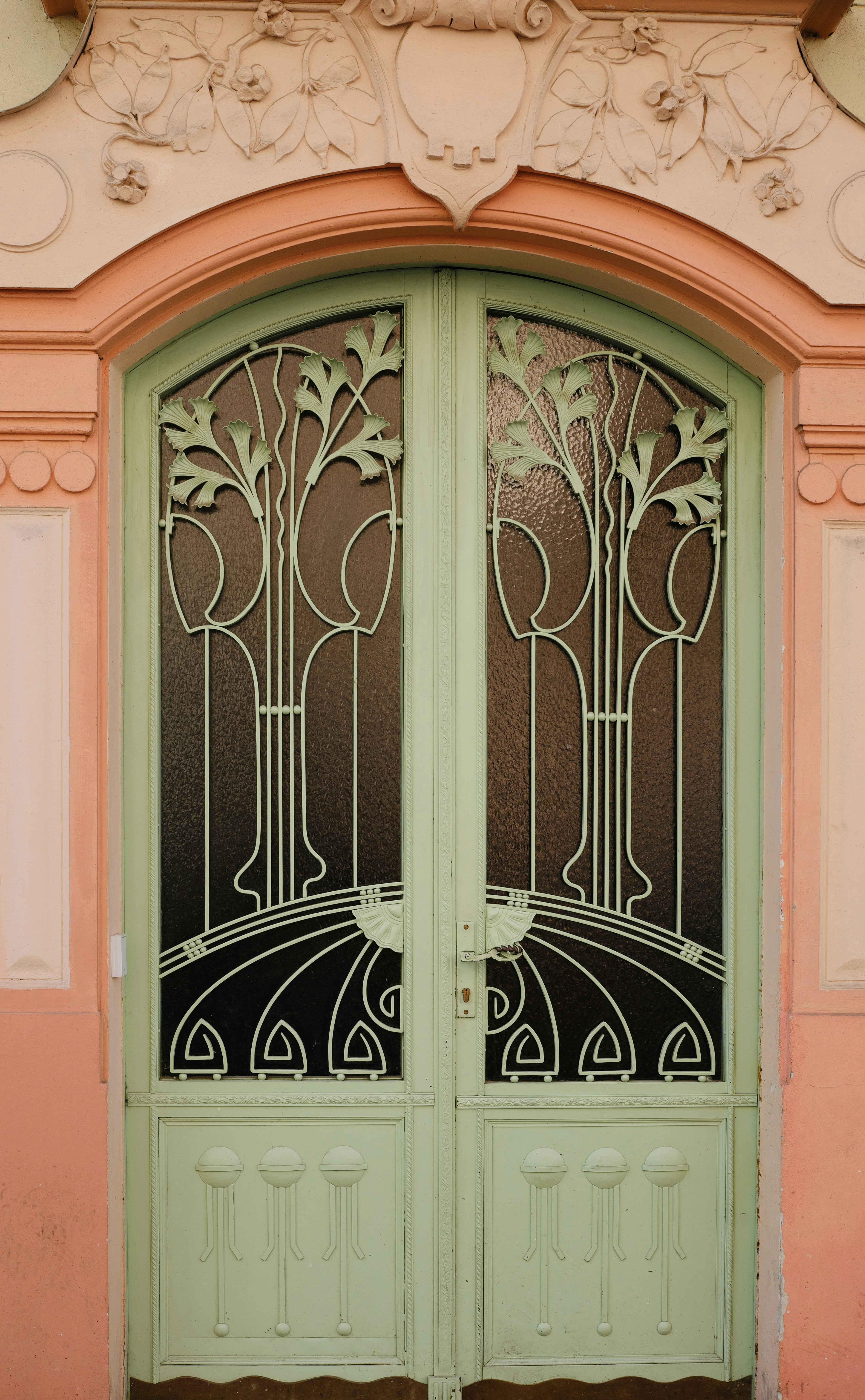 Ornate green double doors with decorative metalwork.
