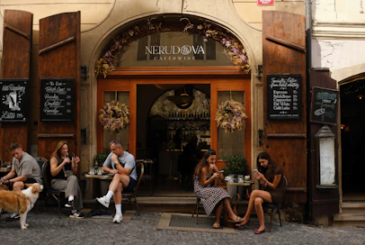 People sit outside a restaurant with open doors
