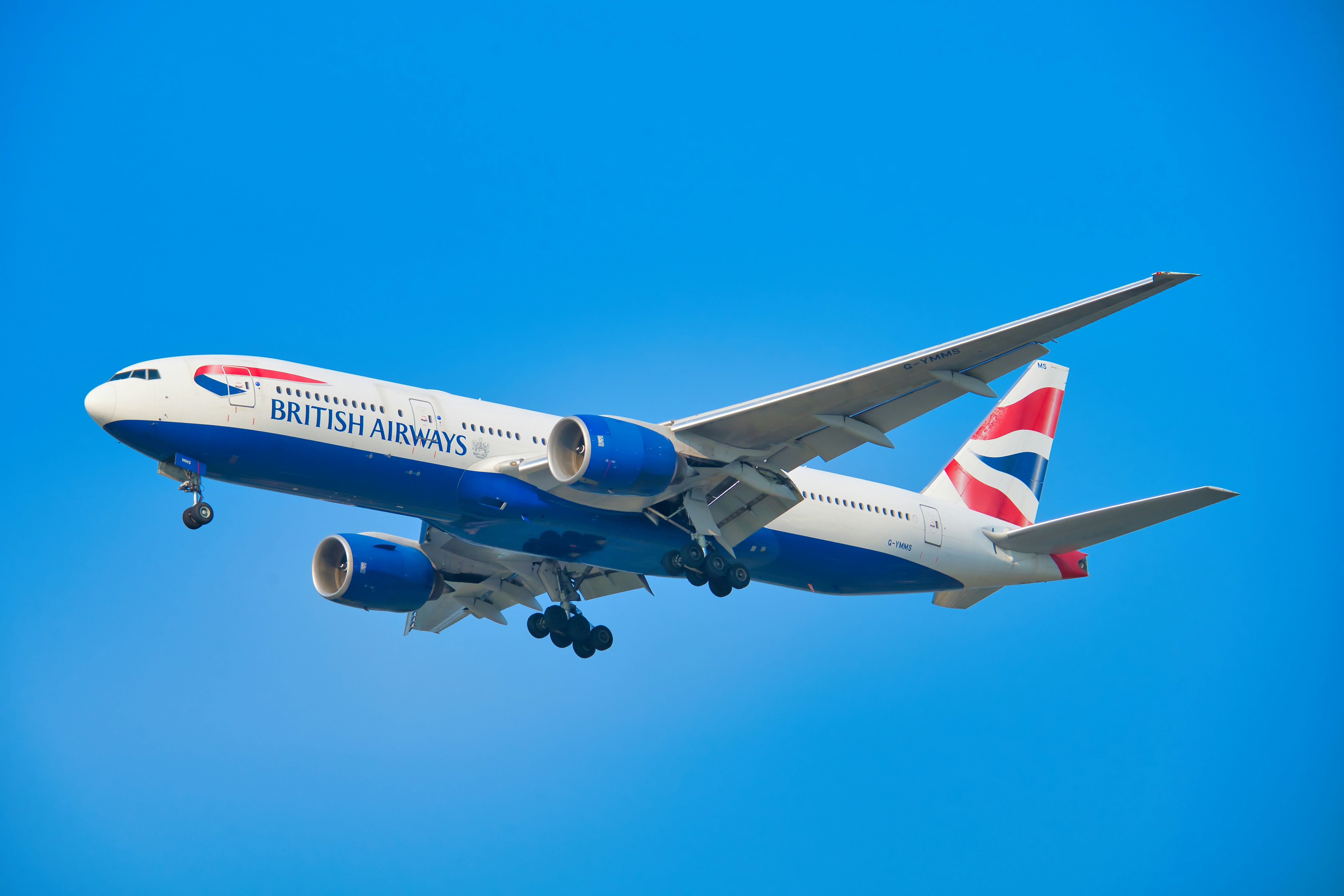 Ein Flugzeug der British Airways, das am strahlend blauen Himmel fliegt.
