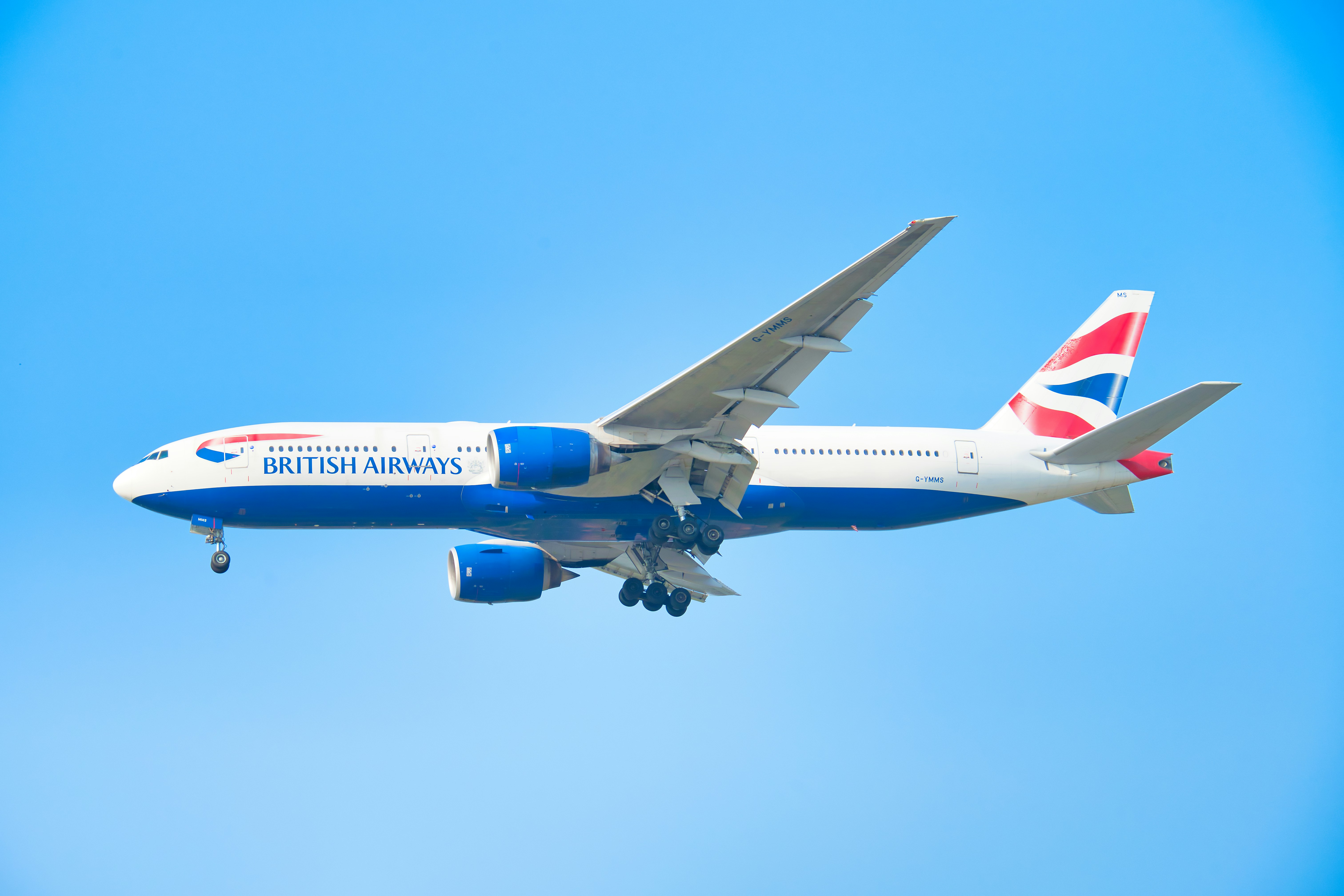 Ein Flugzeug der British Airways, das am strahlend blauen Himmel fliegt.