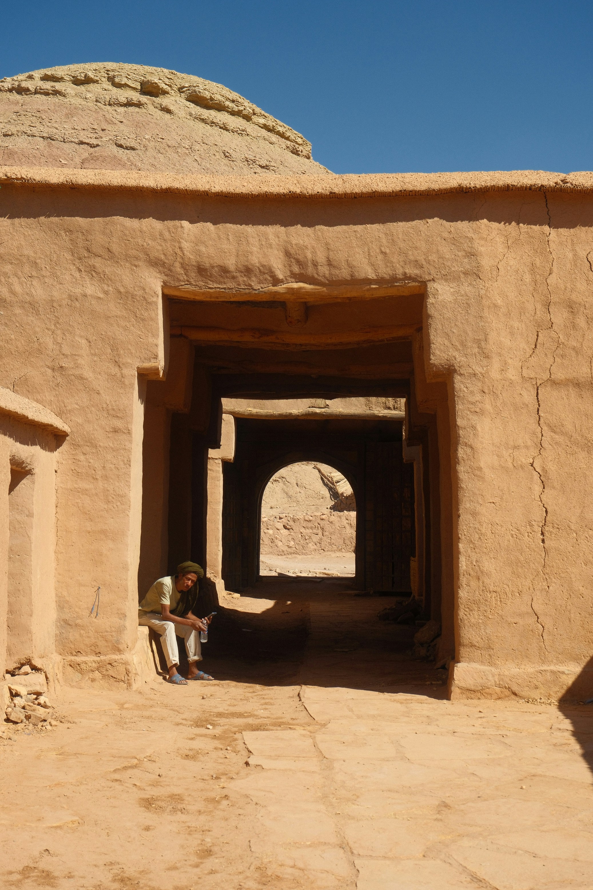 Man sitting in archway of ancient desert building