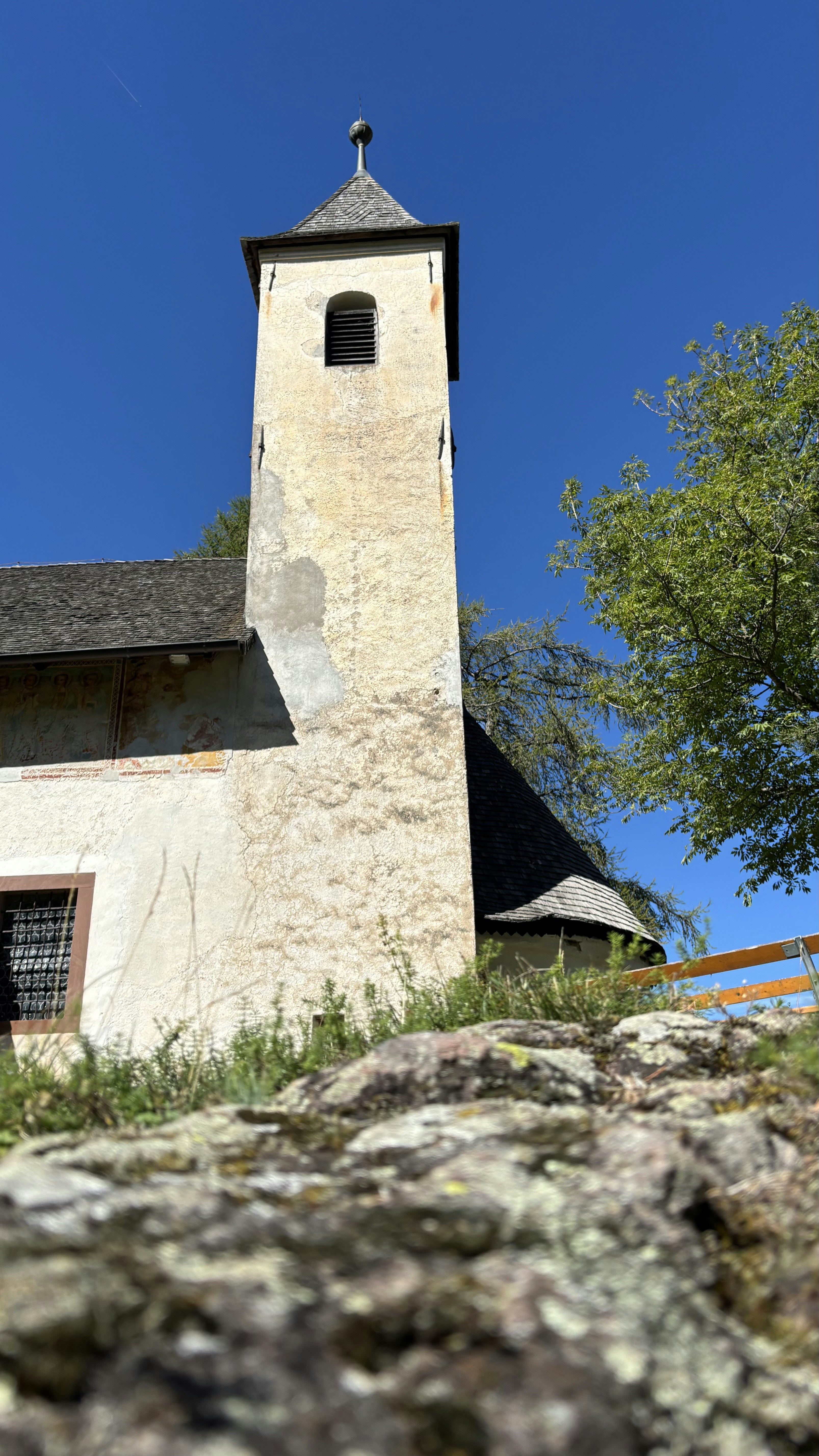 Old stone church tower against a clear blue sky