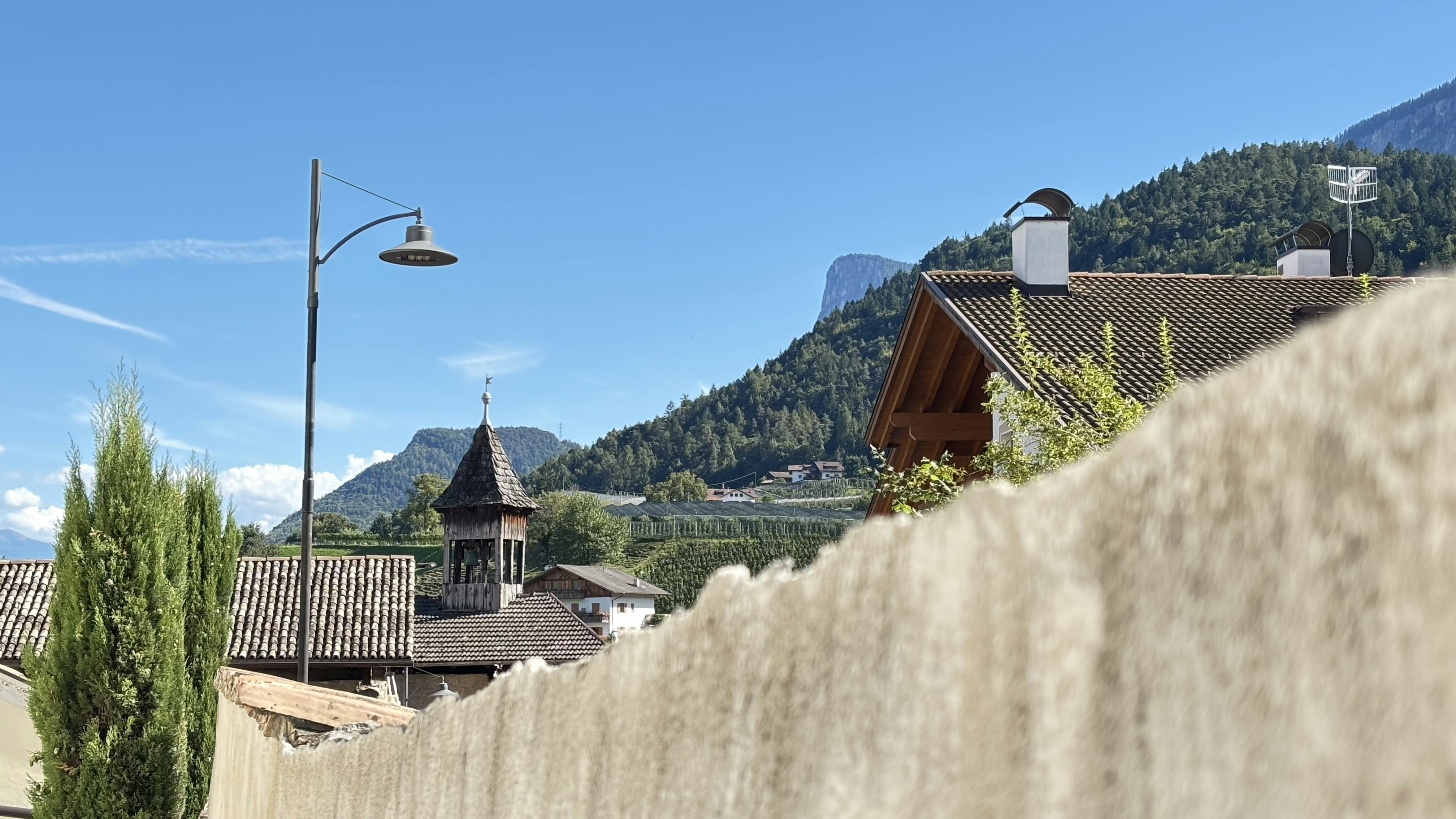 Village with church steeple and mountains under blue sky