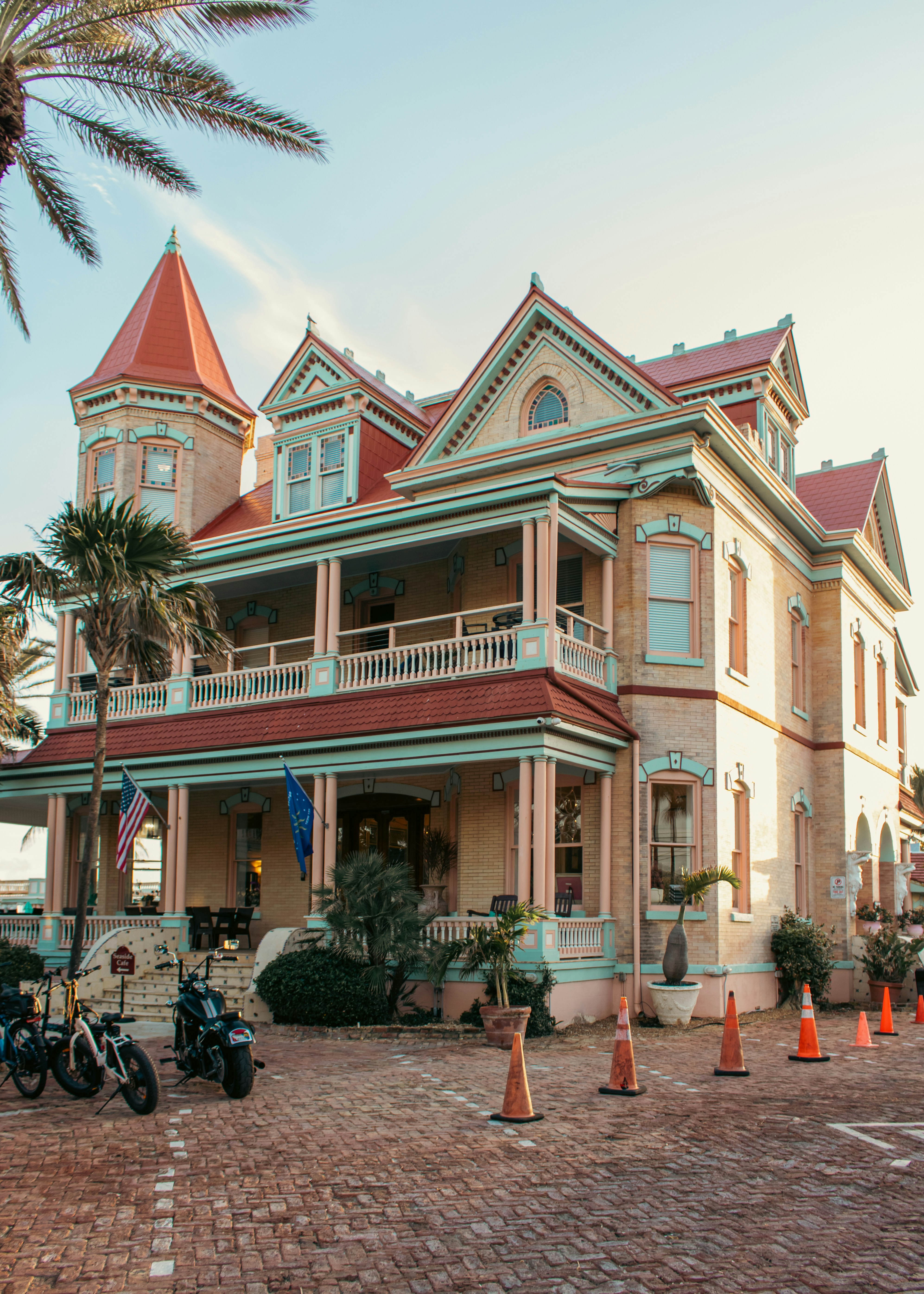 Victorian mansion with red roof and palm trees