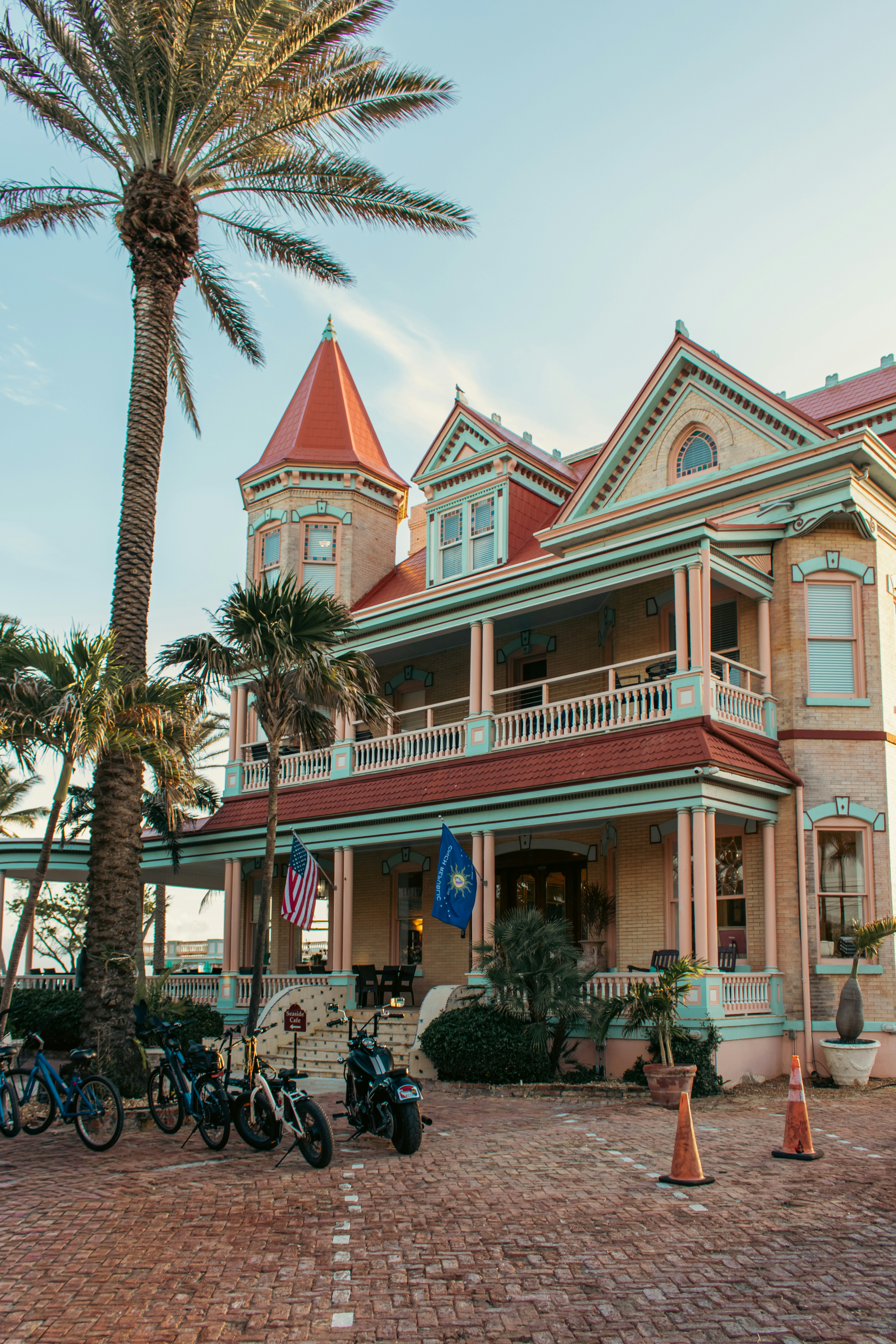 Elaborate Victorian mansion with palm trees and bicycles parked outside in Key West