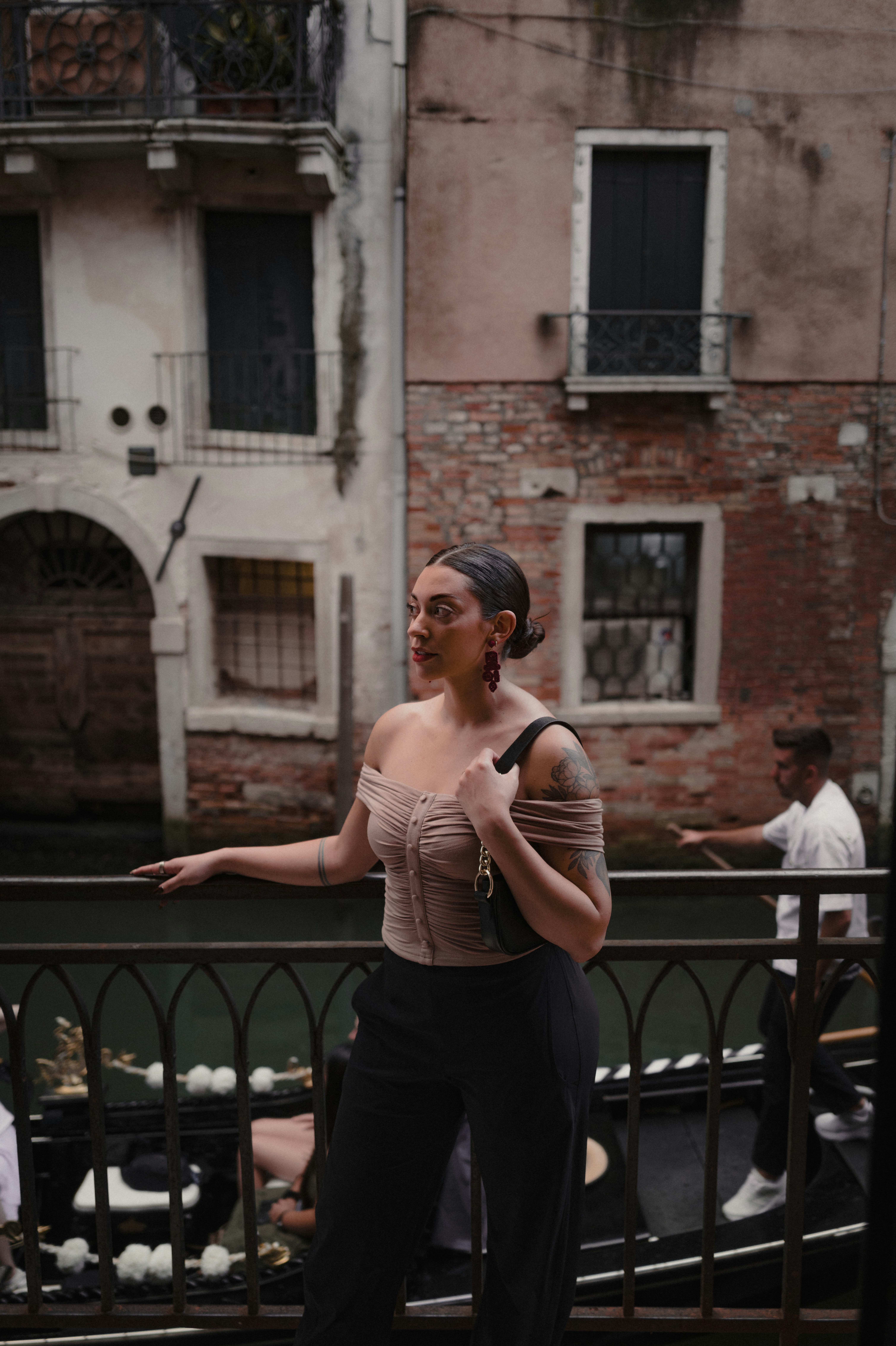 Woman posing on a bridge with gondola in venice.