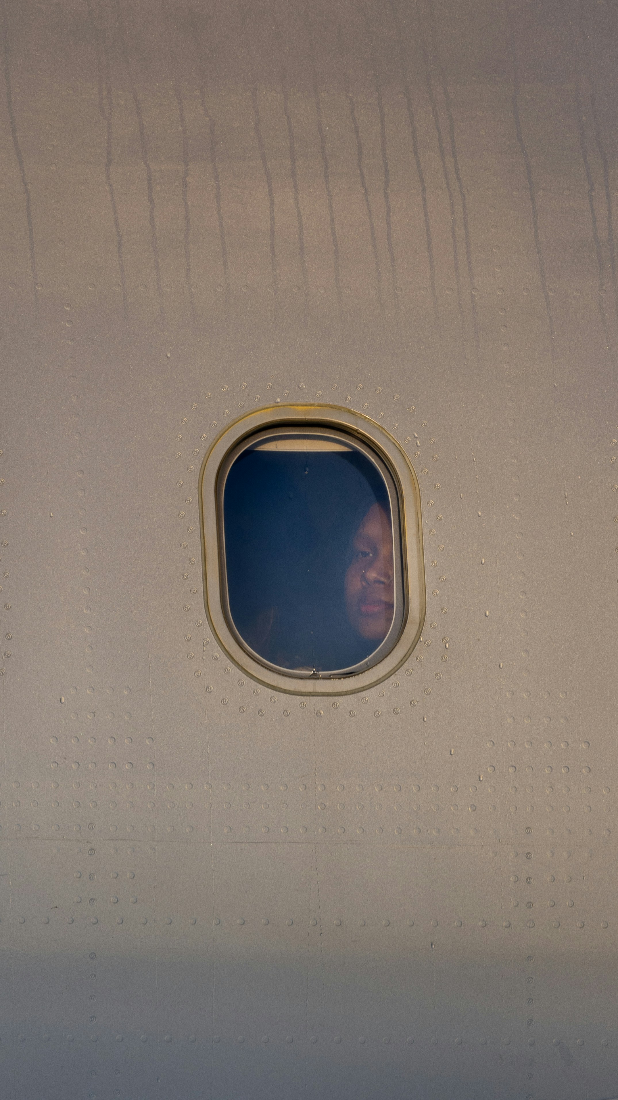 A person looks out an airplane window.