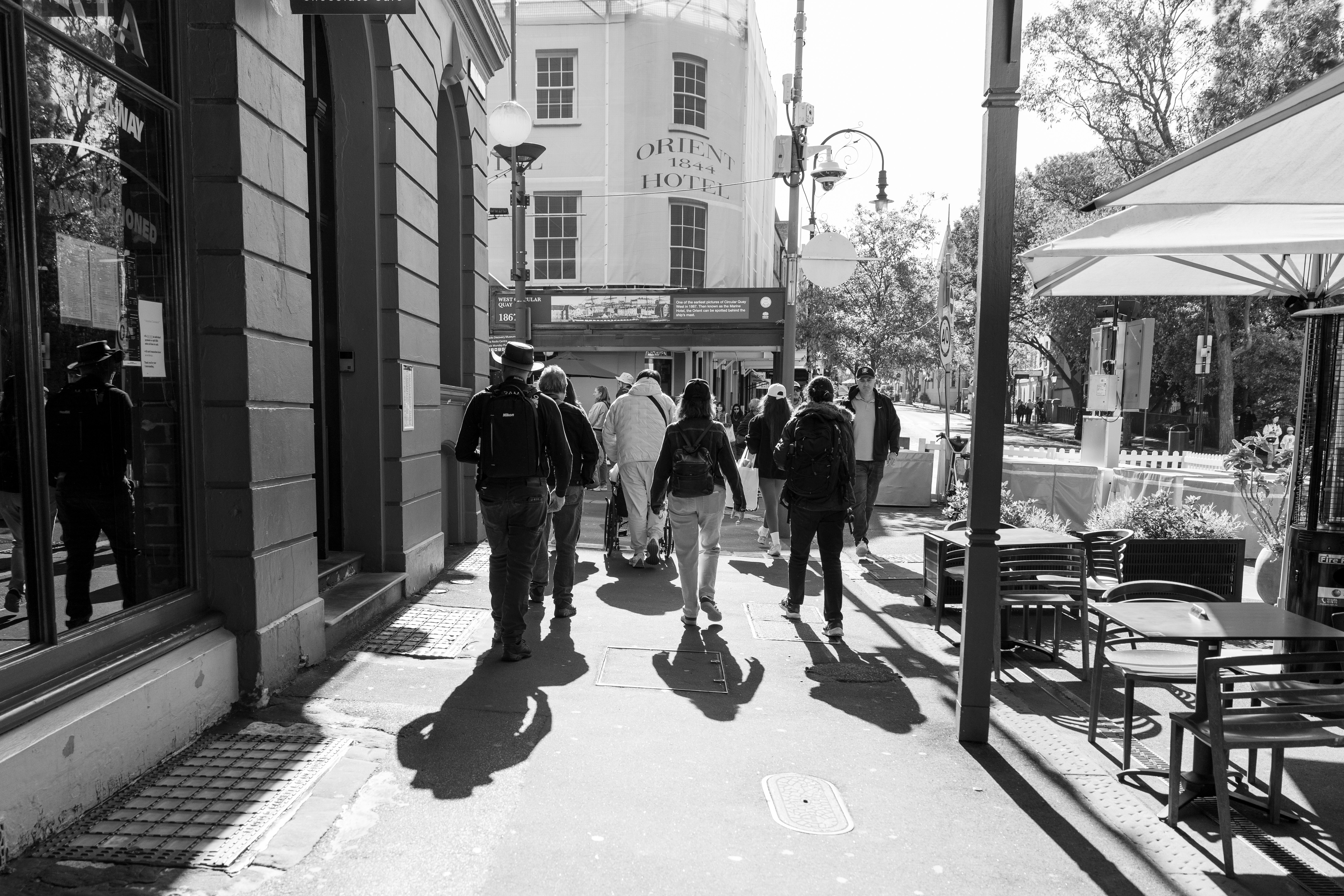 People walking down a sunny city street.