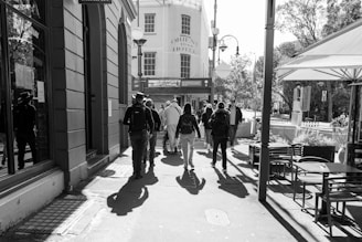 People walking down a sunny city street.