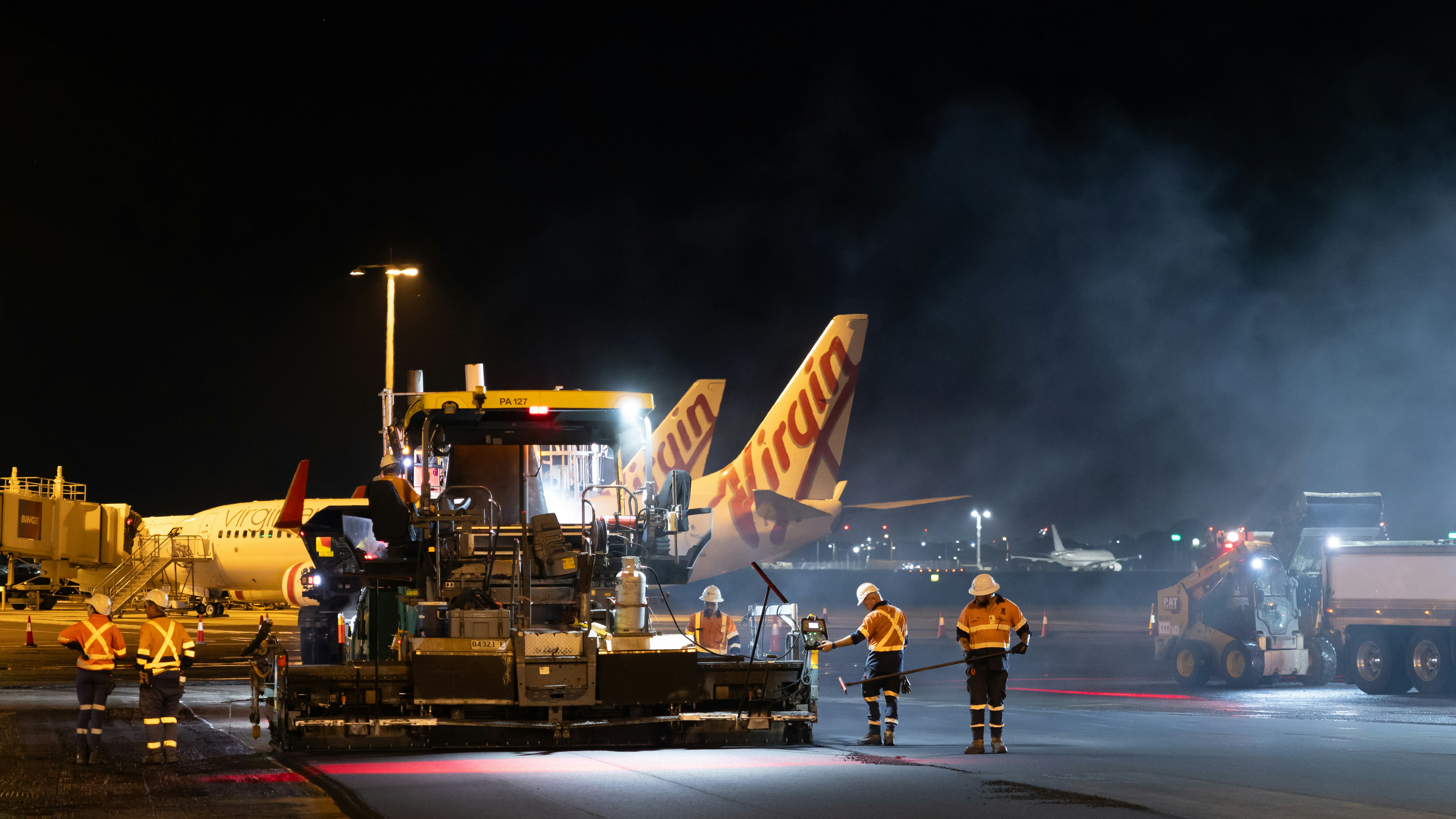 Airport tarmac crew working at night with airplanes