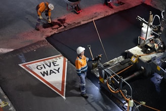 Workers paving a road with asphalt and asphalt machine.