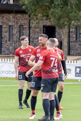 Football players in red jerseys celebrating on field