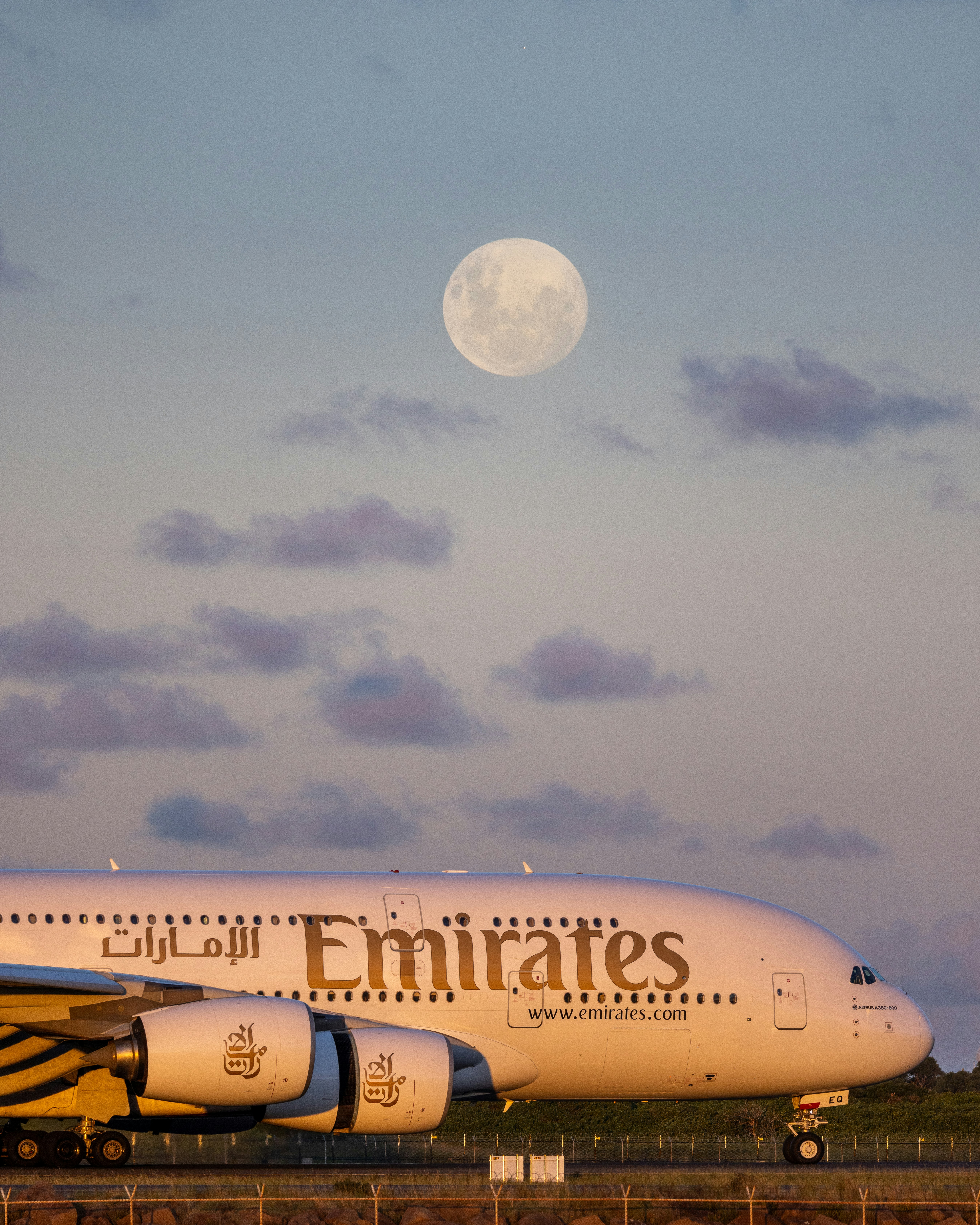 Emirates airplane with full moon in sky