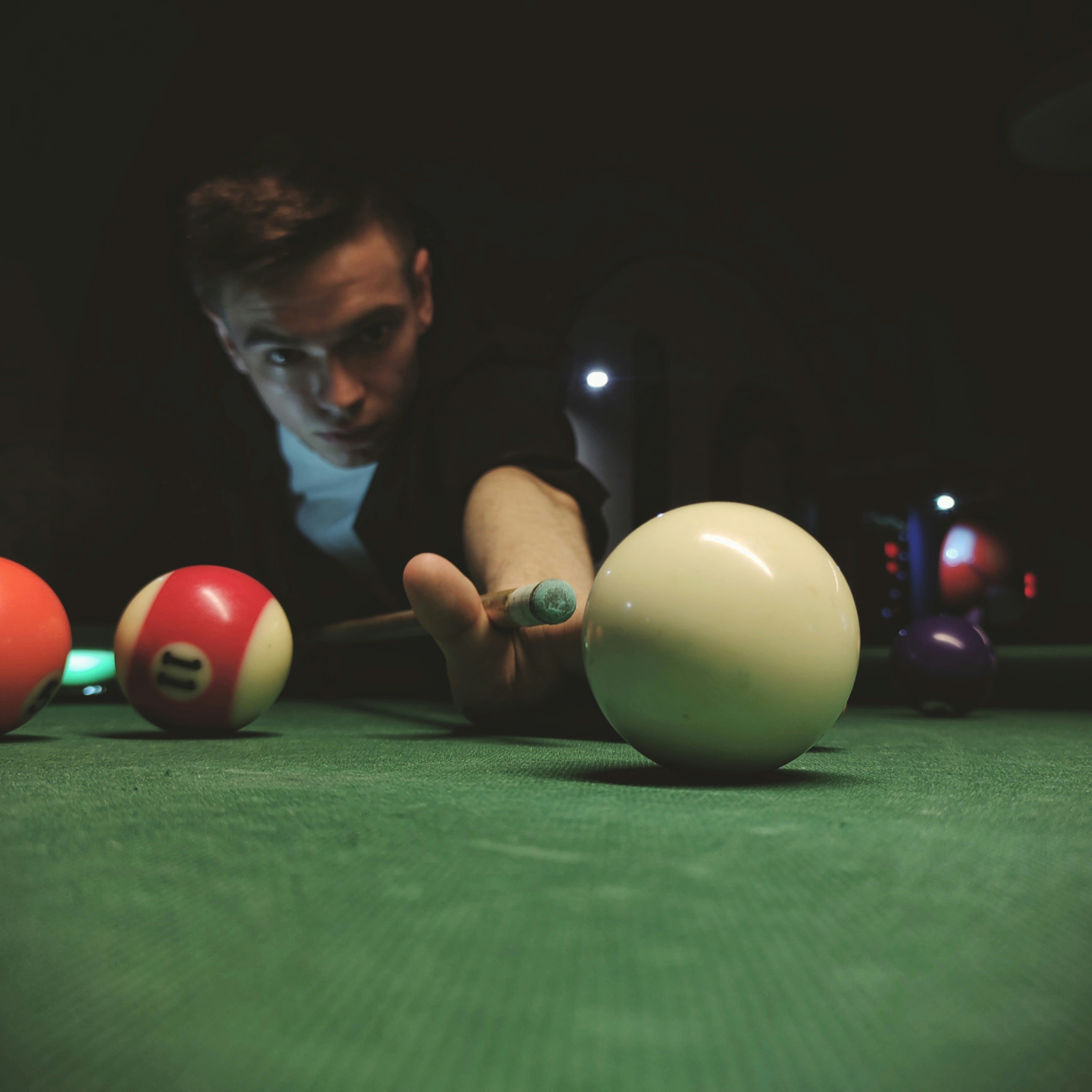 Man playing billiards with cue ball and balls