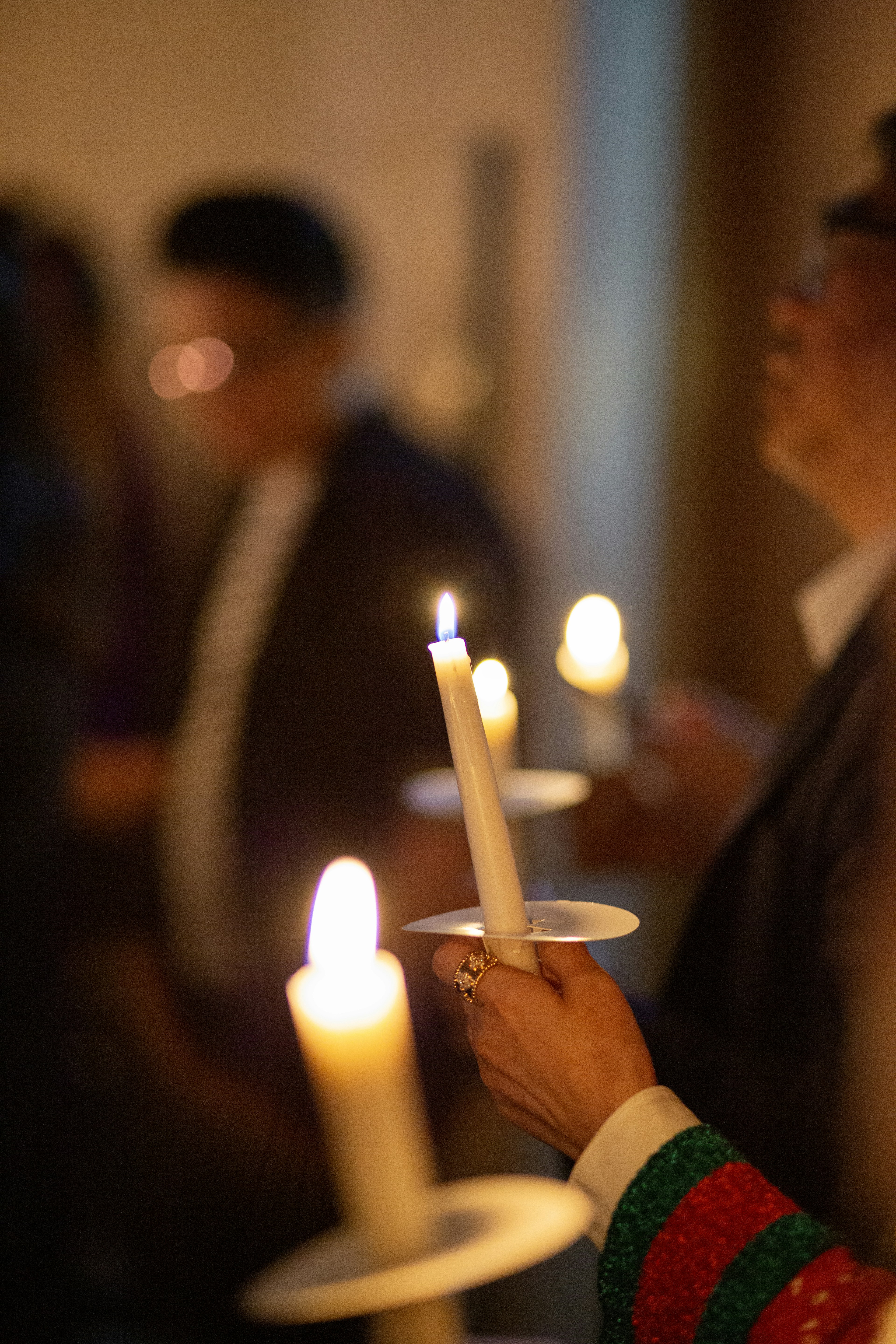 People holding lit candles during an event