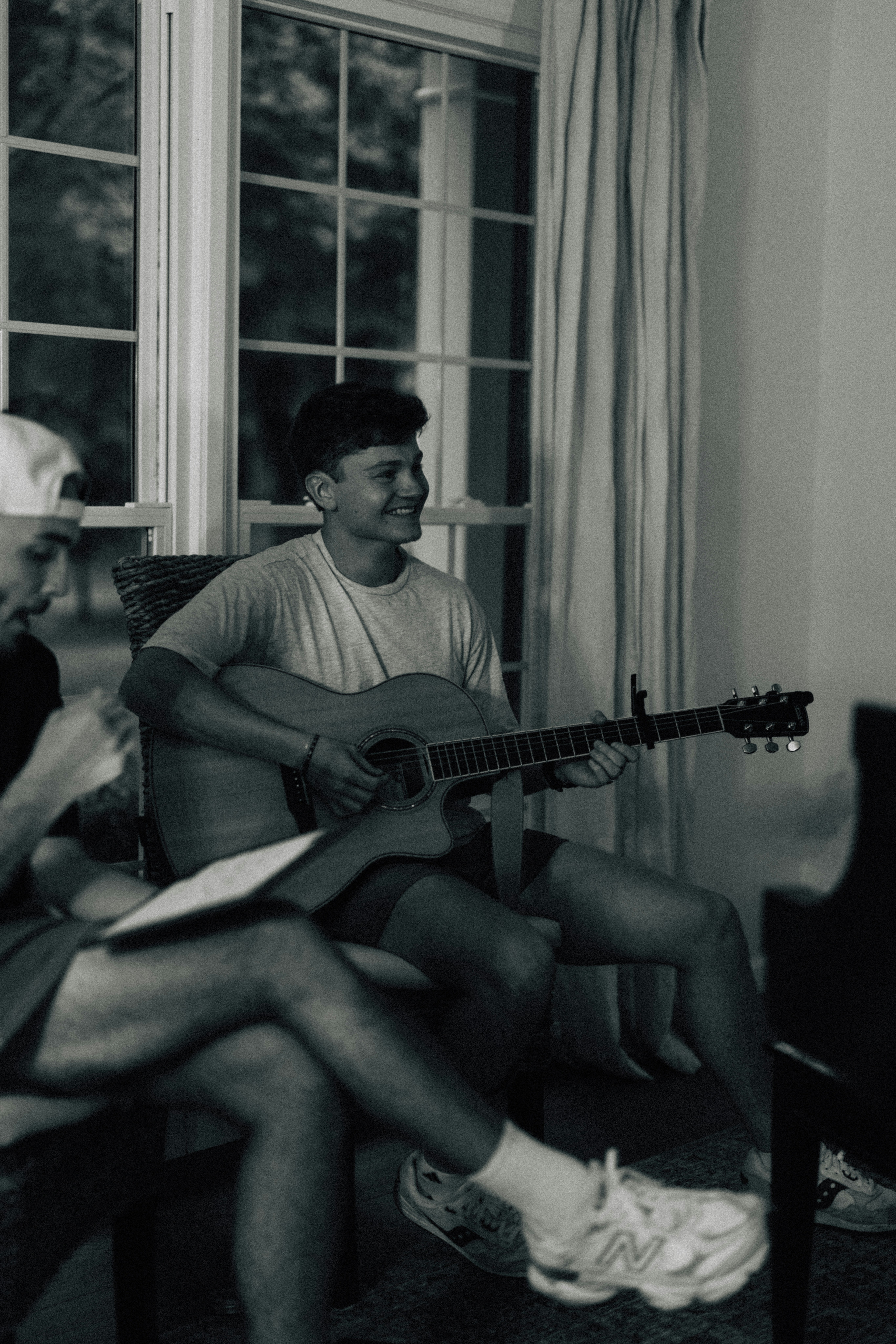 Young man playing acoustic guitar indoors