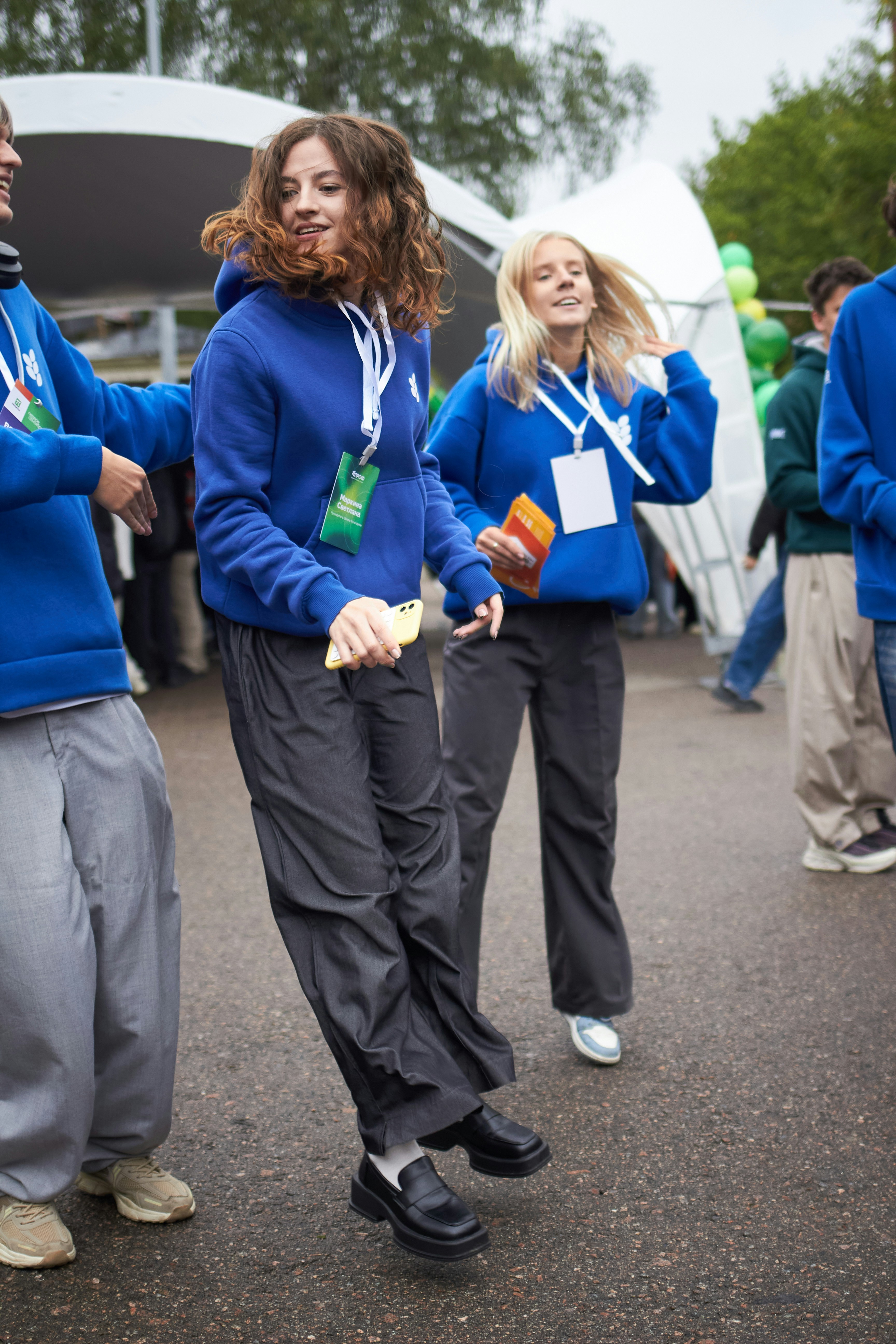 Young people in blue hoodies dancing outdoors