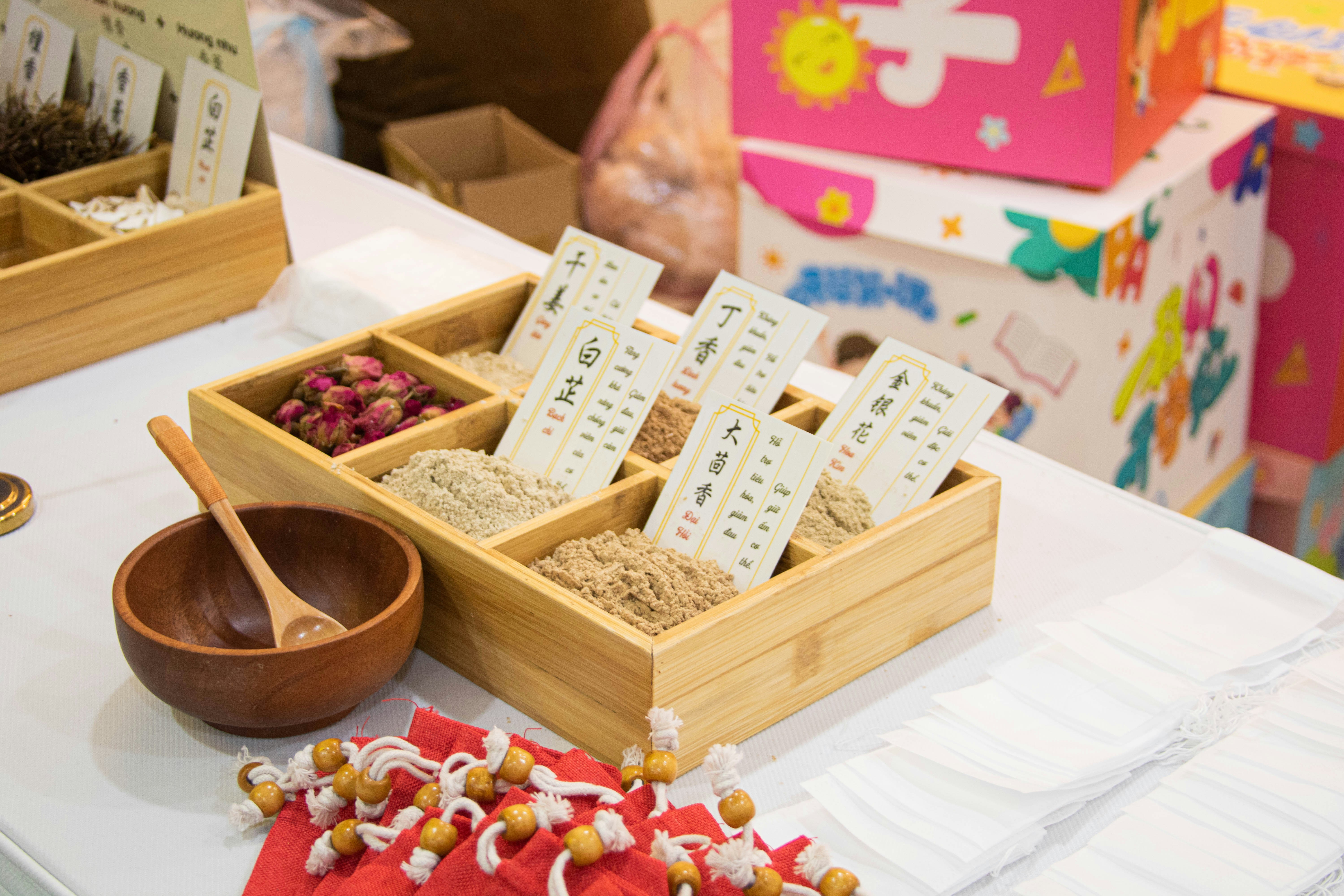 Bandeja de madera con compartimentos de hierbas secas y especias.