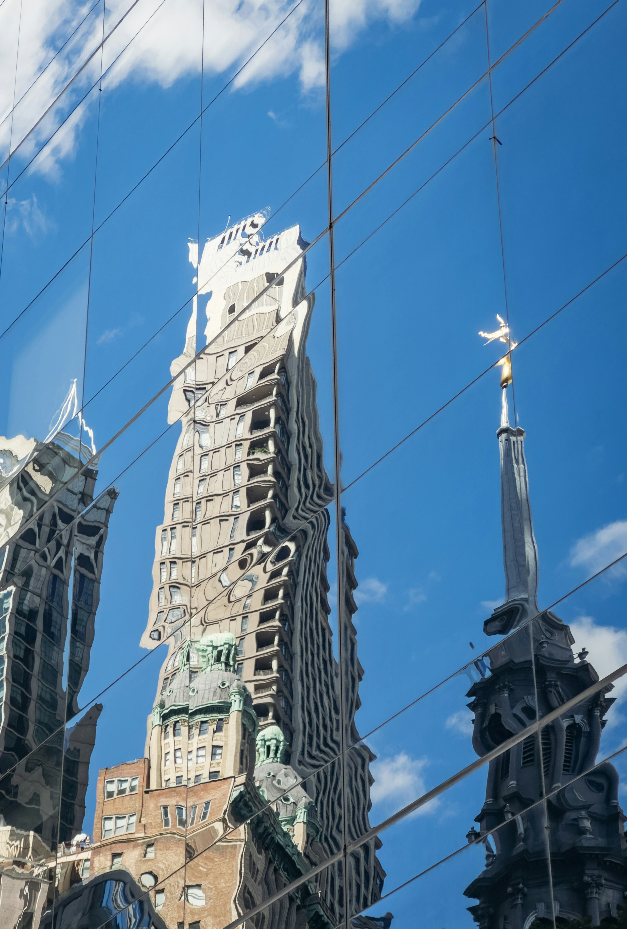 Buildings and sky reflected on a glass facade.