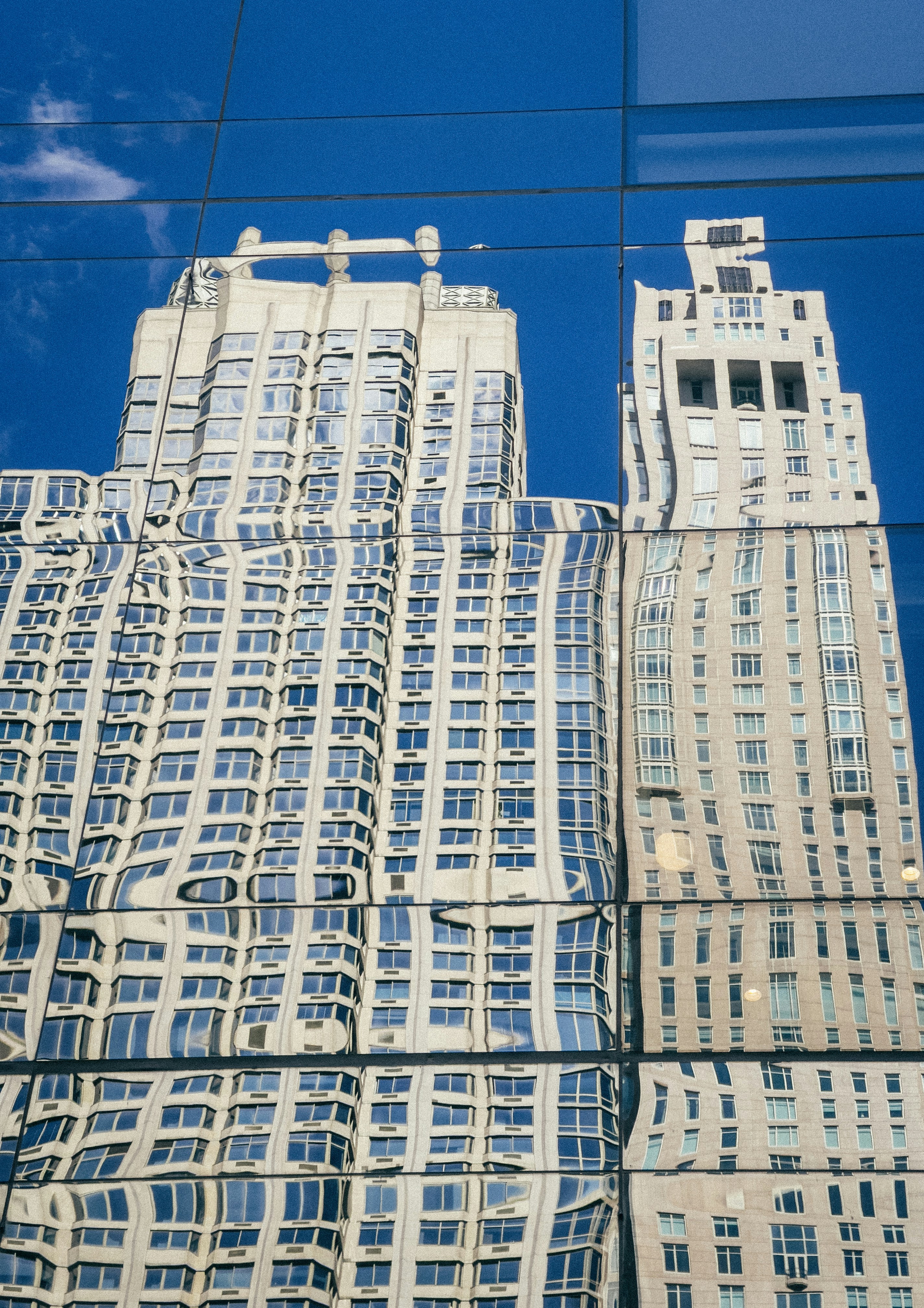 Distorted reflection of buildings on a glass facade.