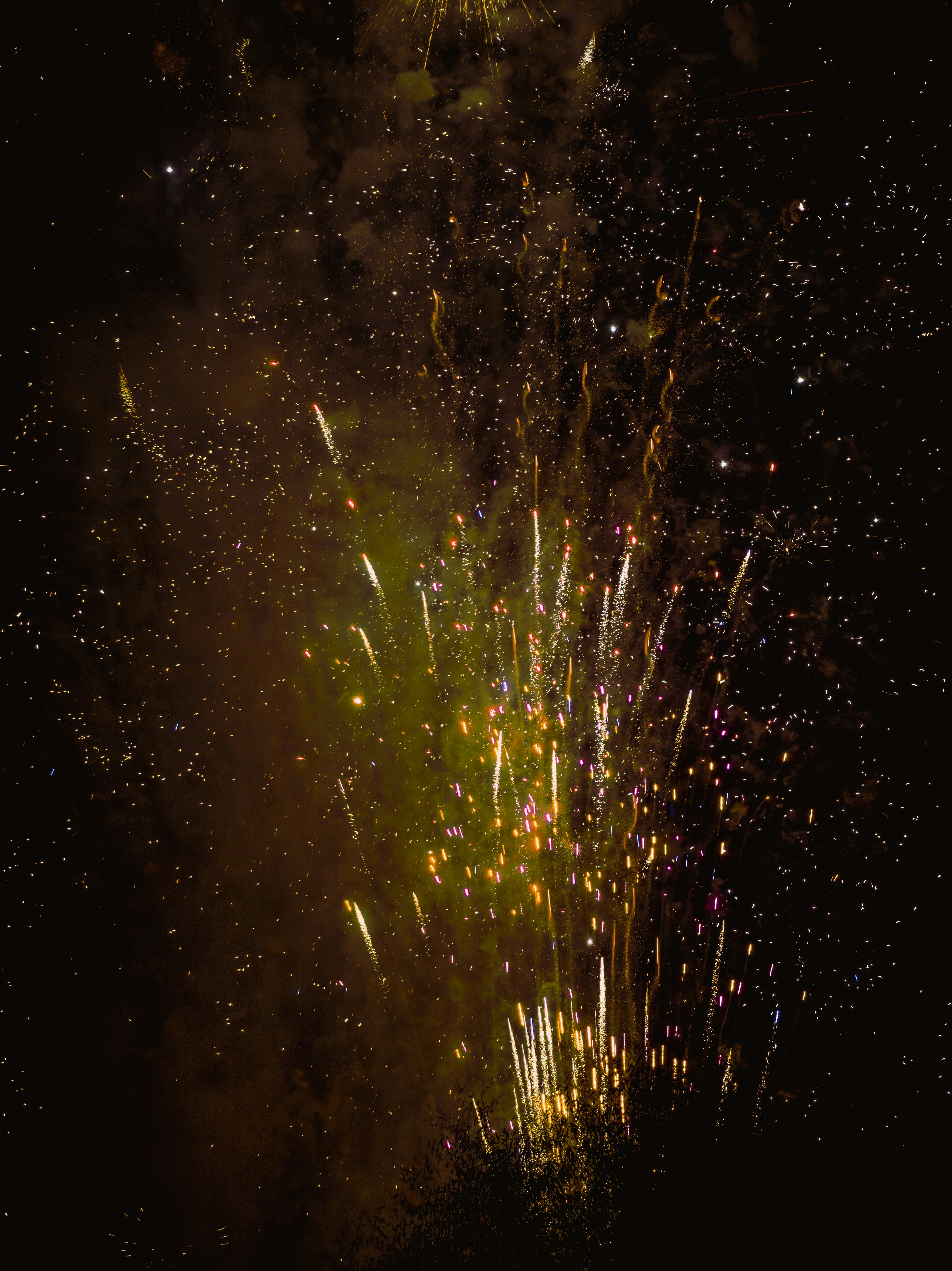 Golden fireworks exploding in the night sky