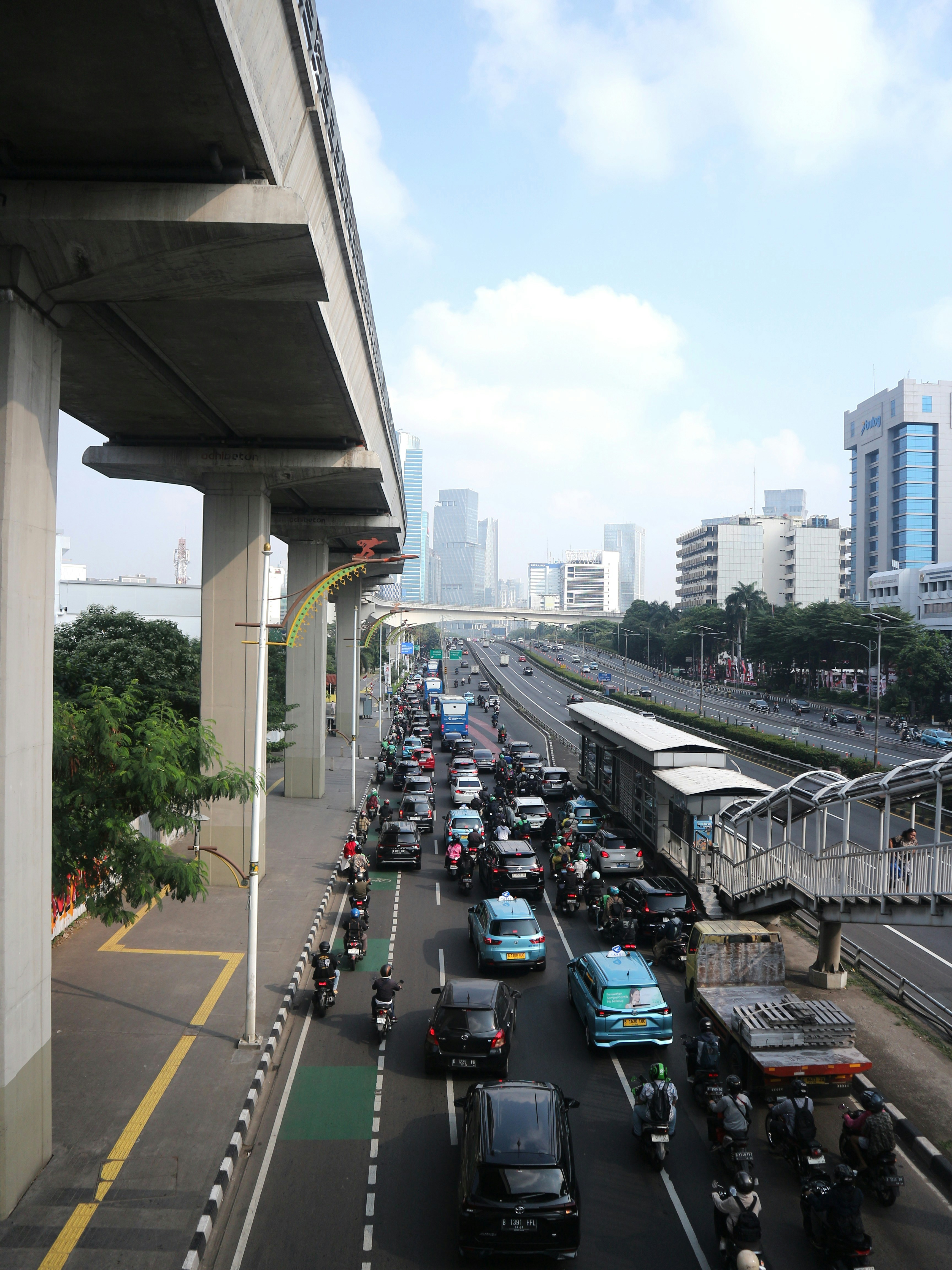 Stark befahrene Stadtstraße mit starkem Verkehr und Hochstraße.