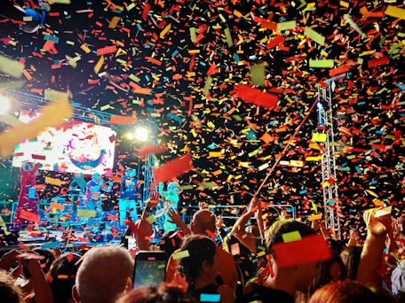 Crowd celebrating with colorful confetti at a concert.