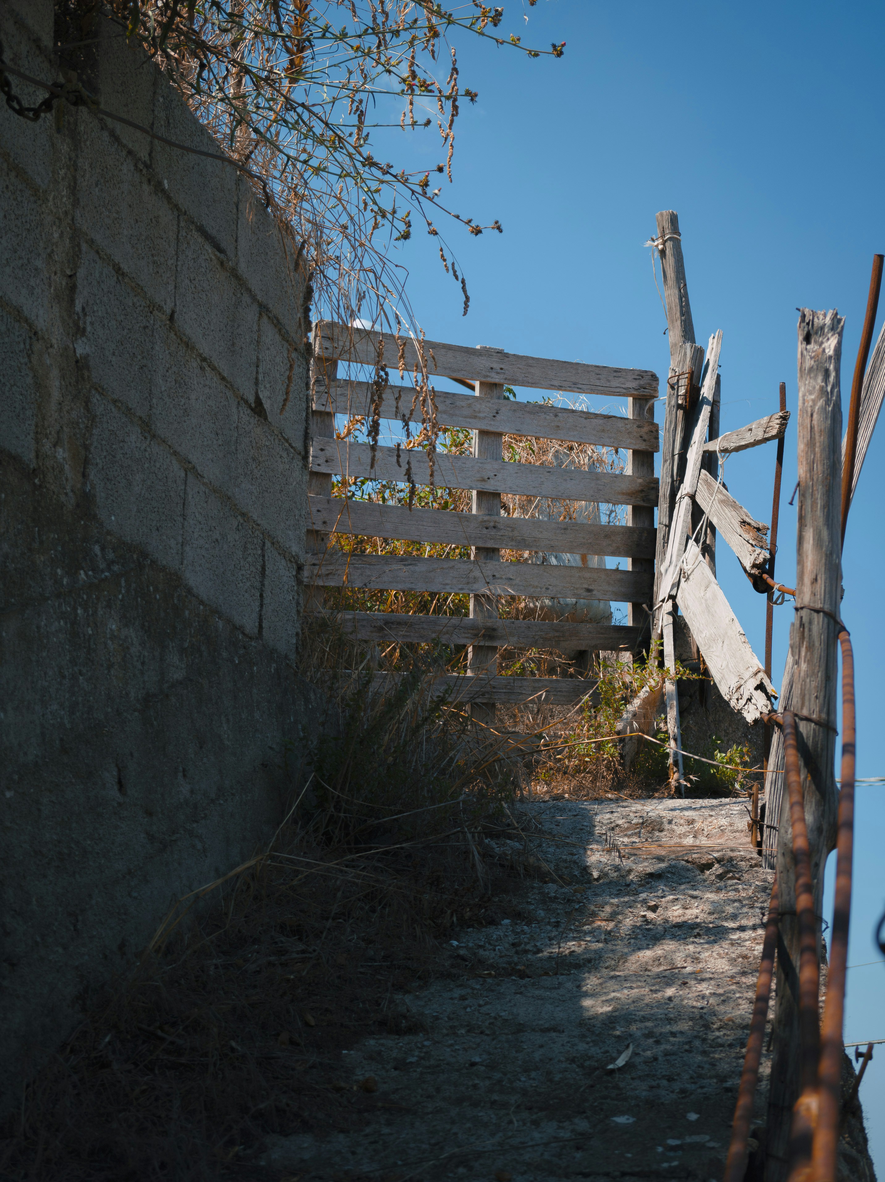 Rustic wooden gate against a clear blue sky