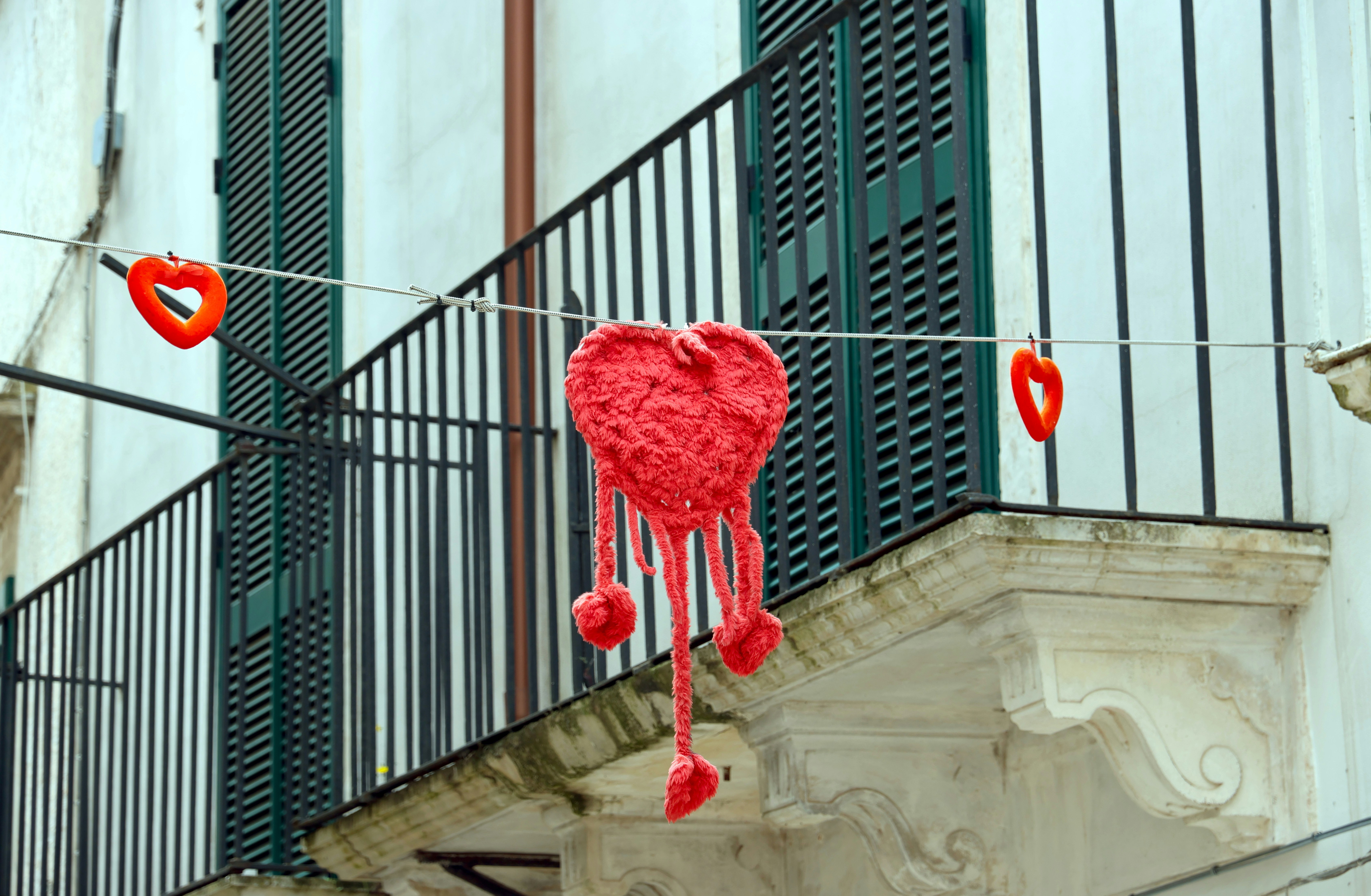Red hearts decoration hanging on a wire.