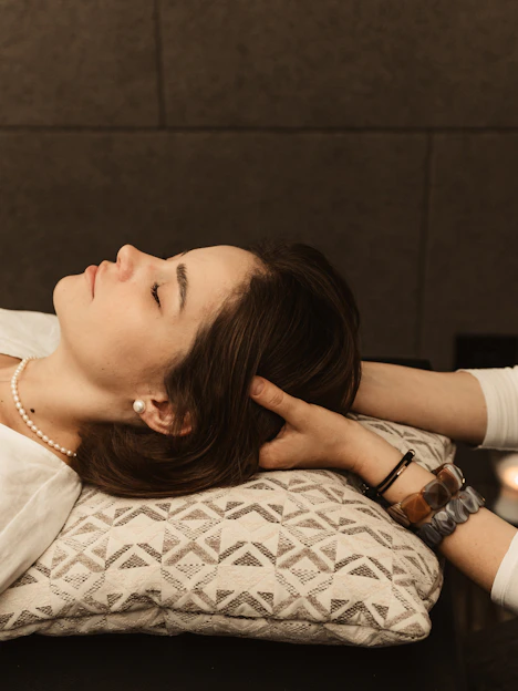 Woman receiving a head massage on a pillow