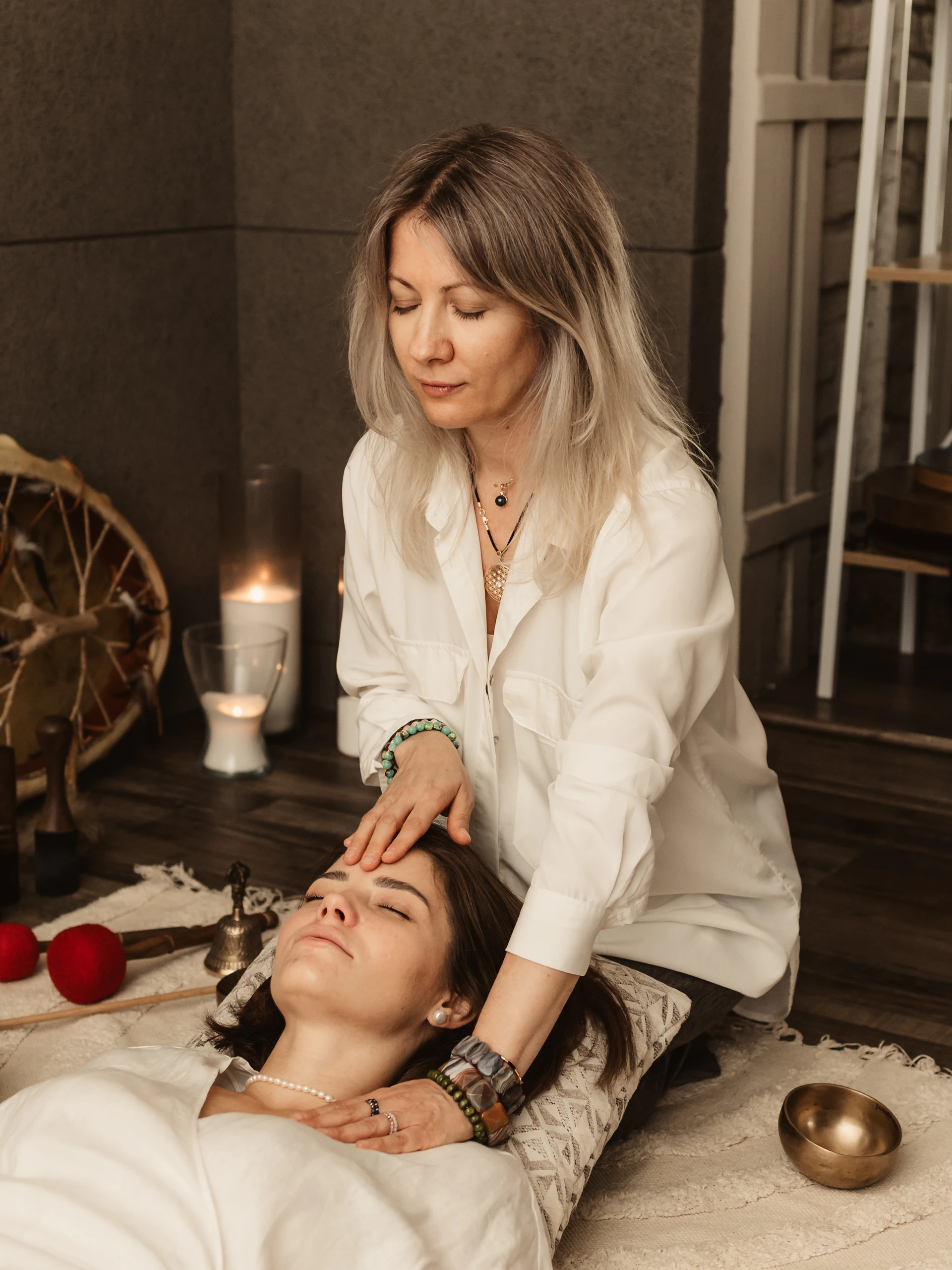 Therapist gently touching woman's forehead during session