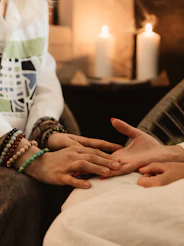 Hands being read by a fortune teller with candles