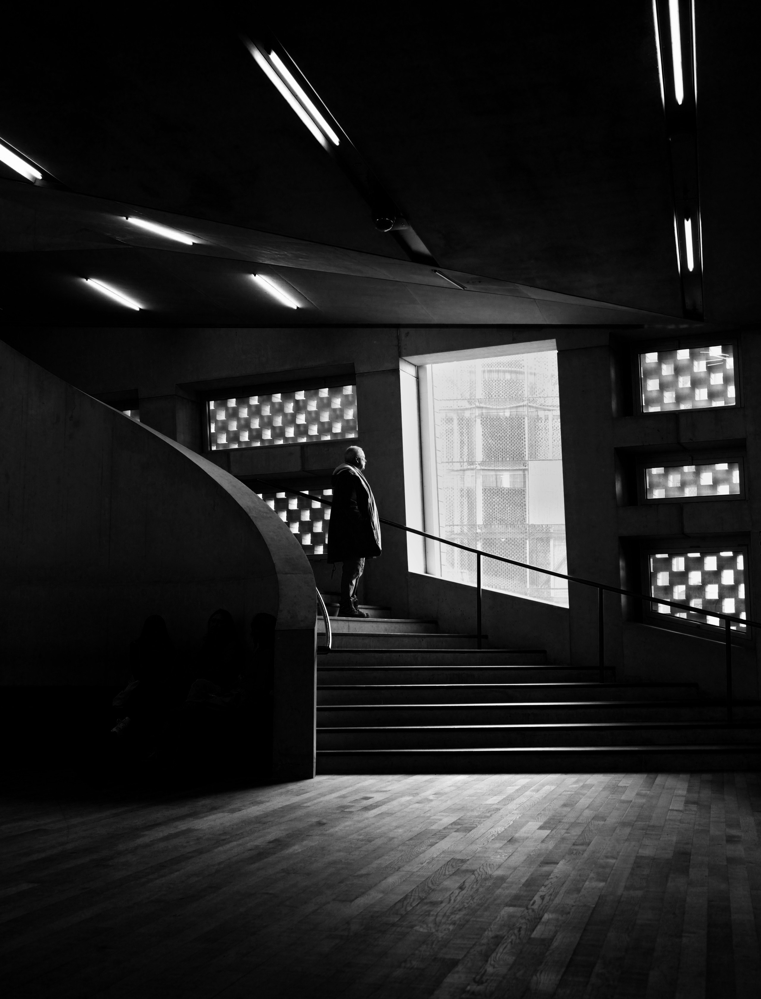 Person walks up stairs towards a large window.