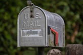 A weathered u.s. mailbox with a red flag.