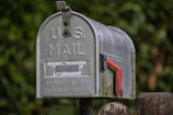A weathered u.s. mailbox with a red flag.