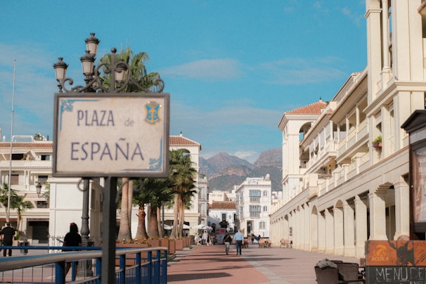 Plaza espana sign with buildings and mountains.