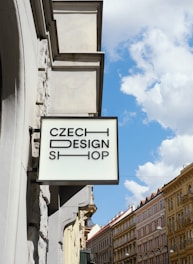 A sign for czech design shop hangs outdoors.