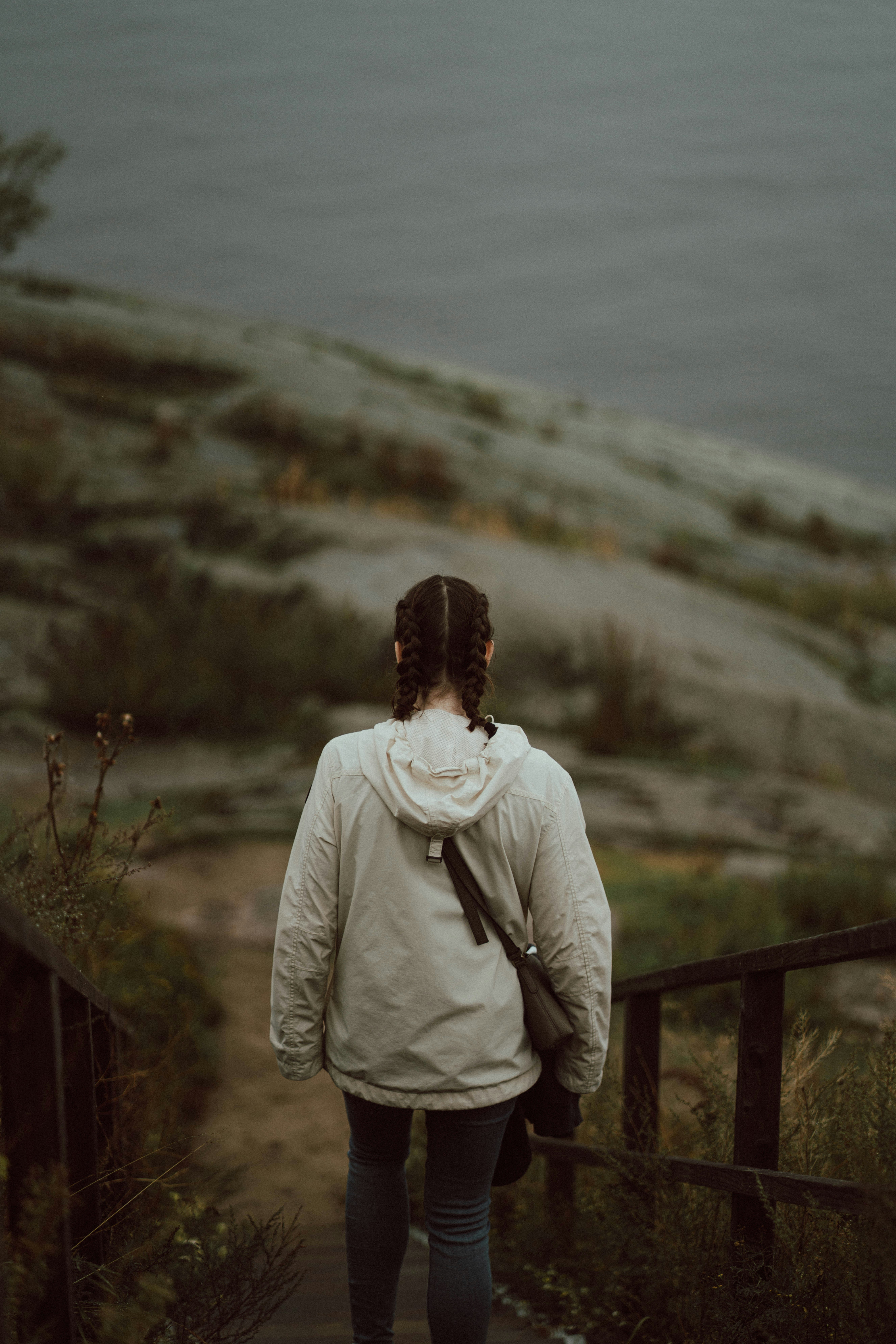 A person walks down stairs towards the water.