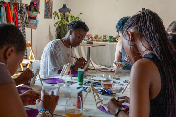 People painting at a table in an art class.