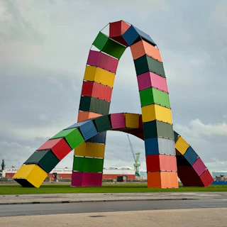 Large colorful shipping container sculpture shaped like letter a
