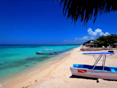 Tropical beach with boats and clear blue ocean