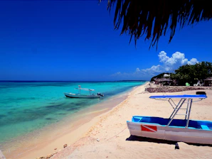 Tropical beach with boats and clear blue ocean