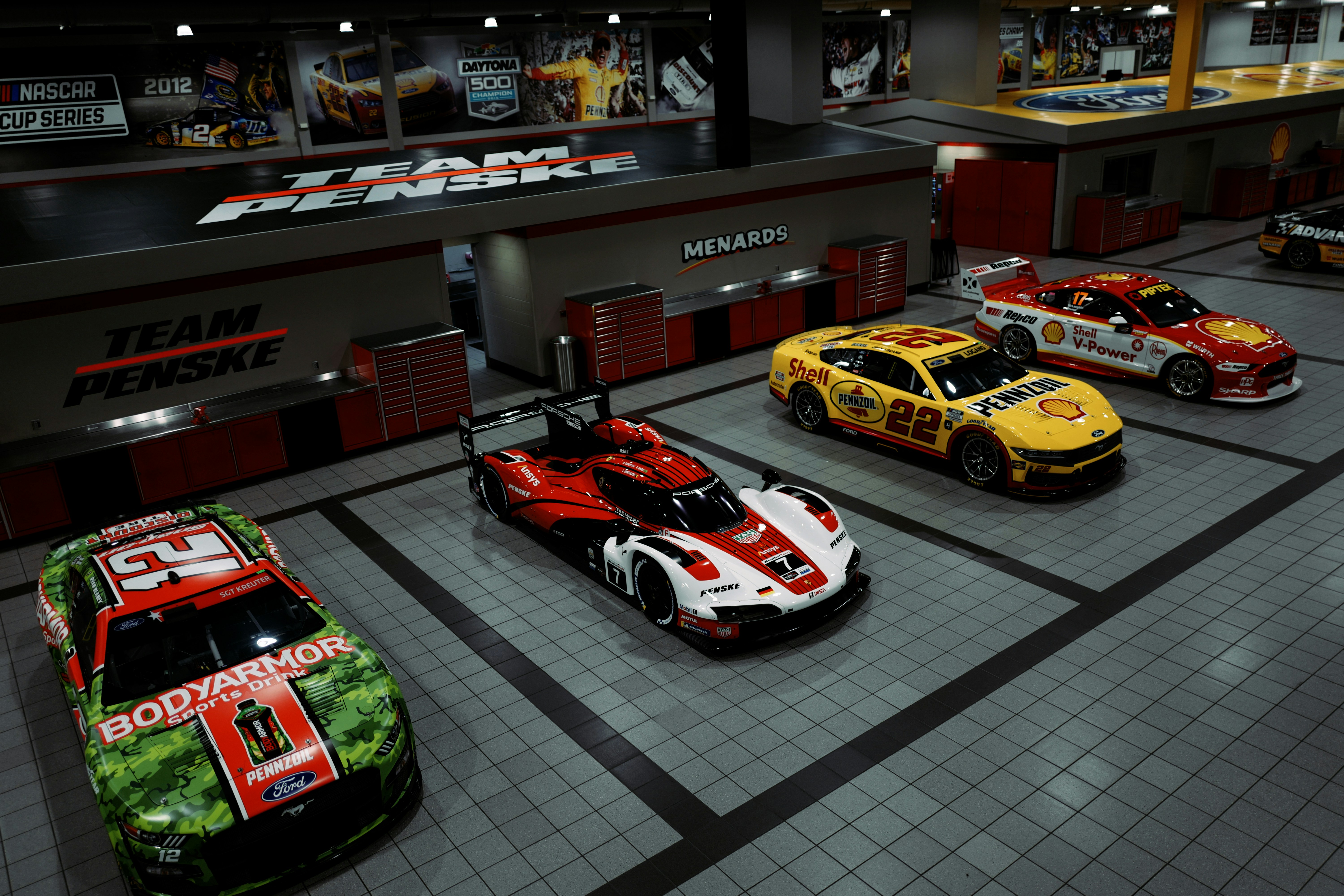 Four race cars parked in a garage
