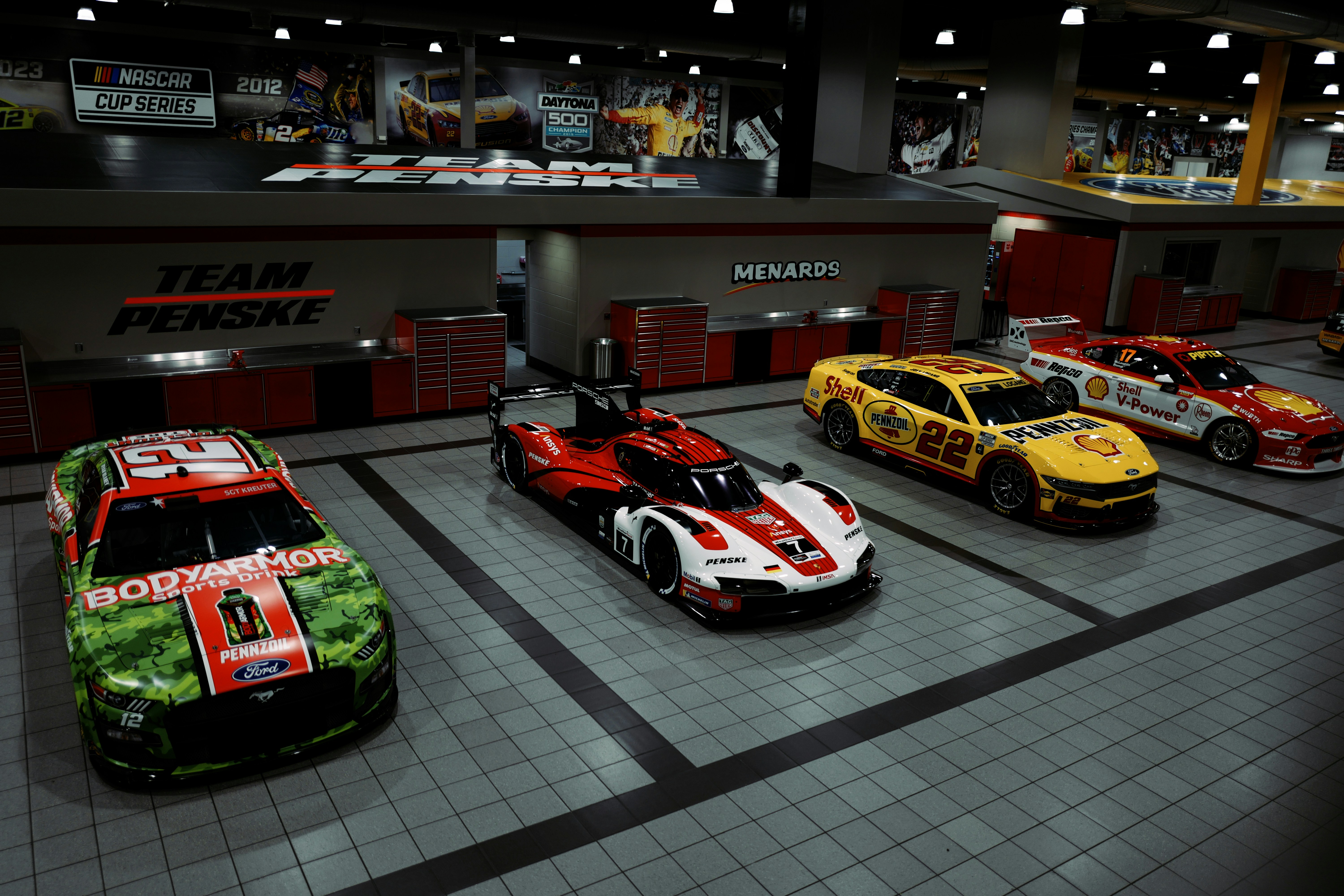 Four race cars parked in a garage