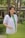 A woman in a lab coat smiles outdoors.