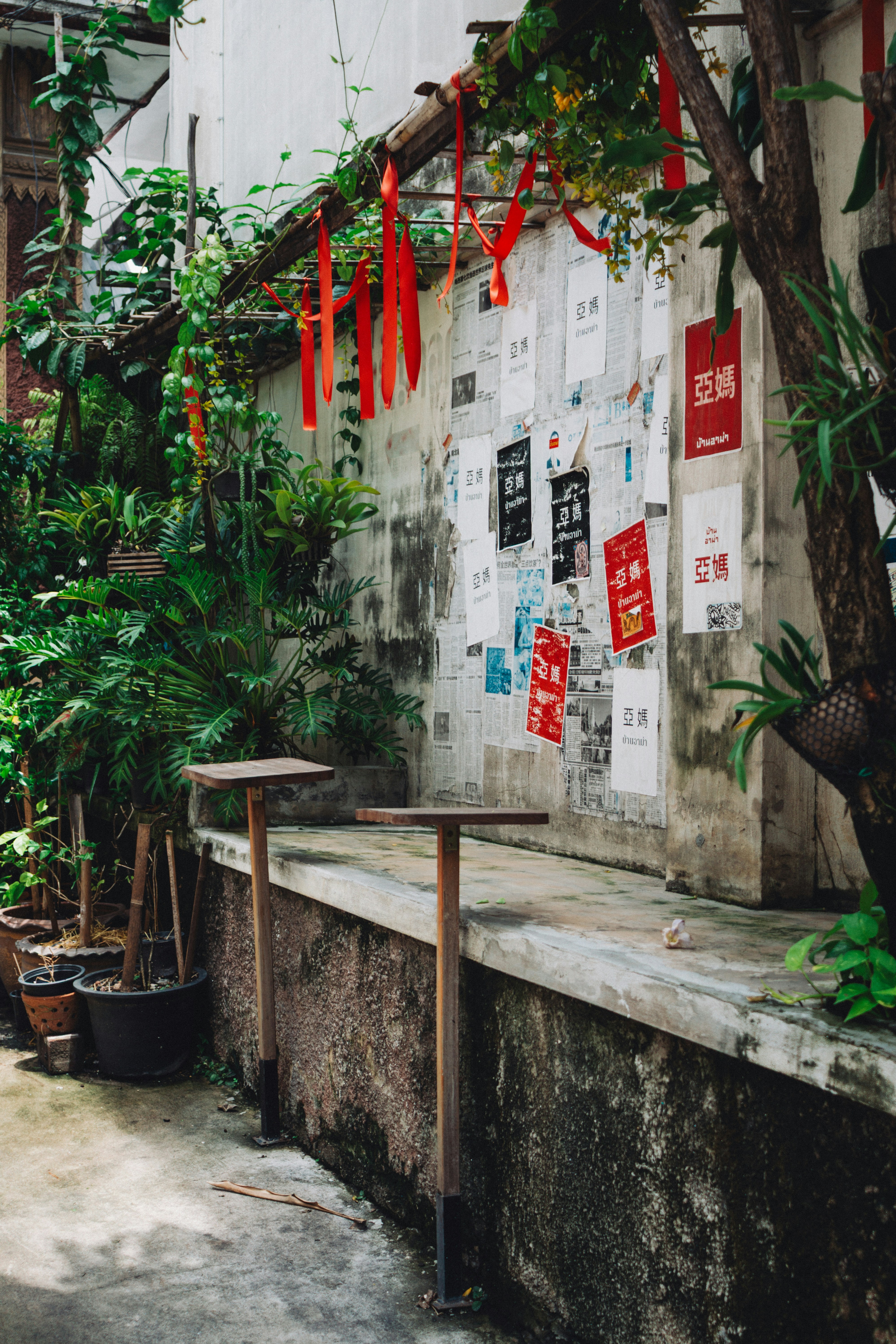 Wall covered in posters with red ribbons hanging.