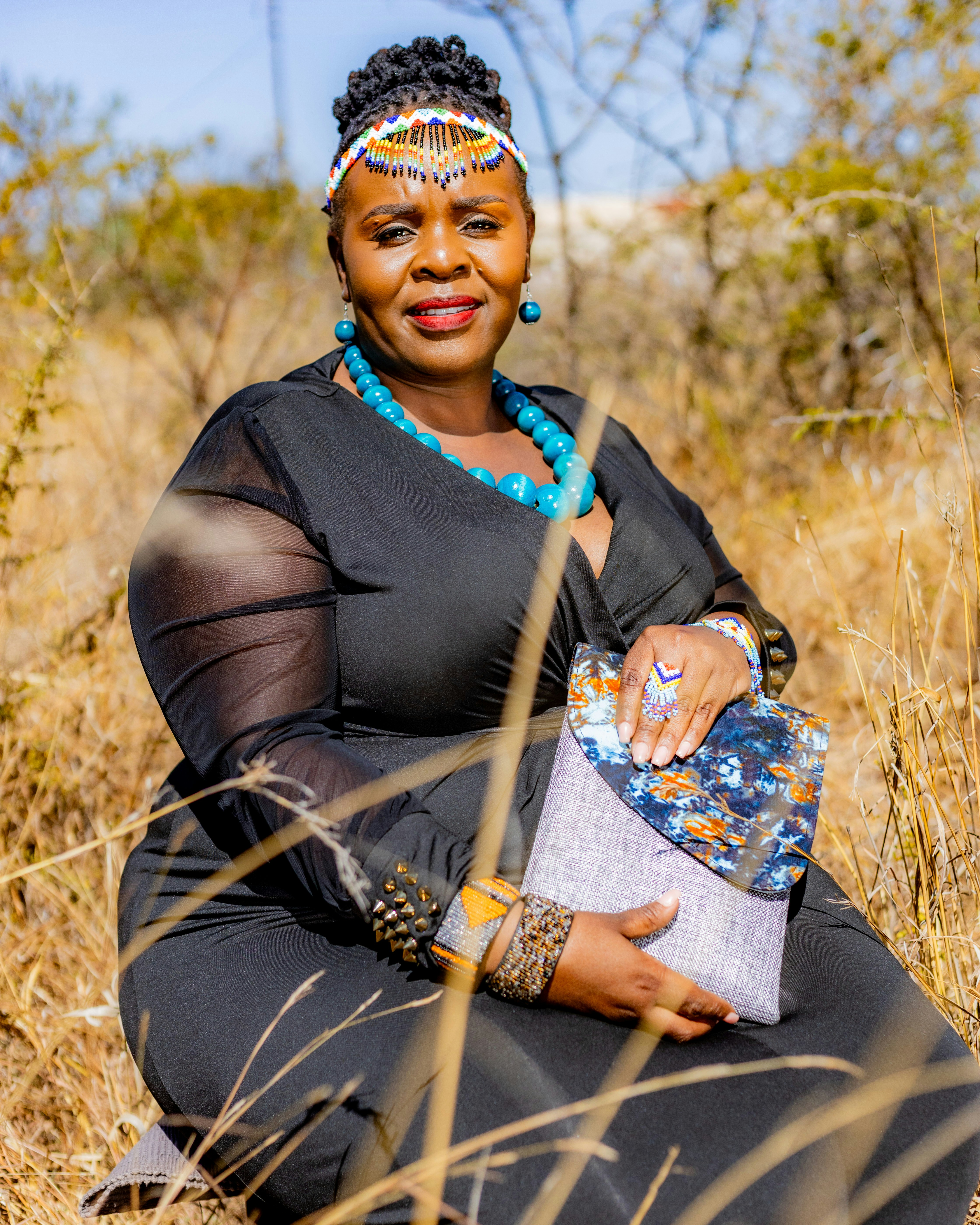 A woman wearing traditional attire in a dry landscape.